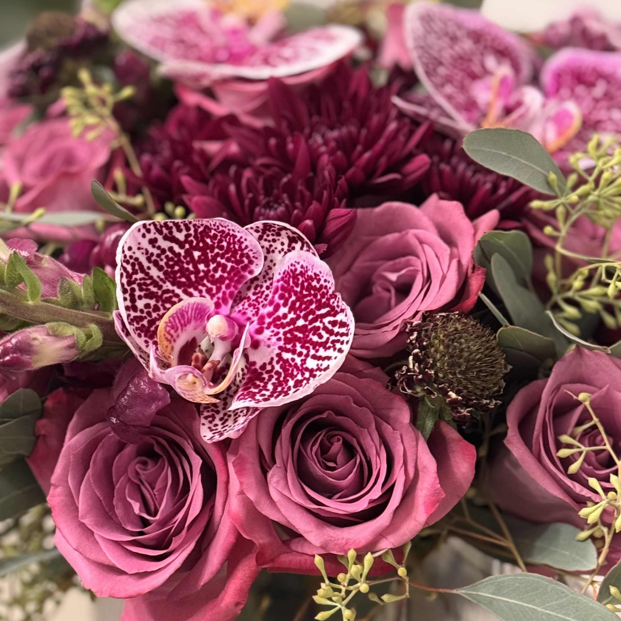 Pink roses and a speckled orchid in a bouquet