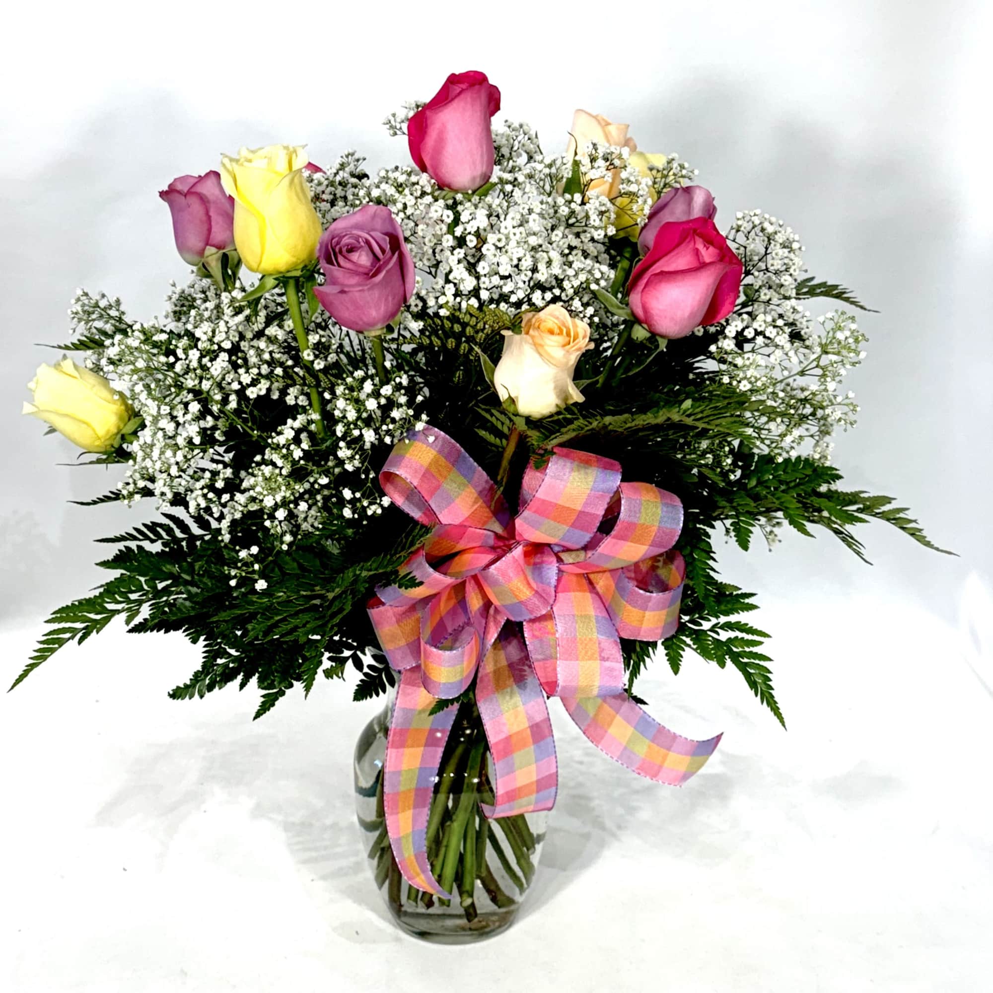 Bouquet of multicolored roses with baby's breath in a glass vase