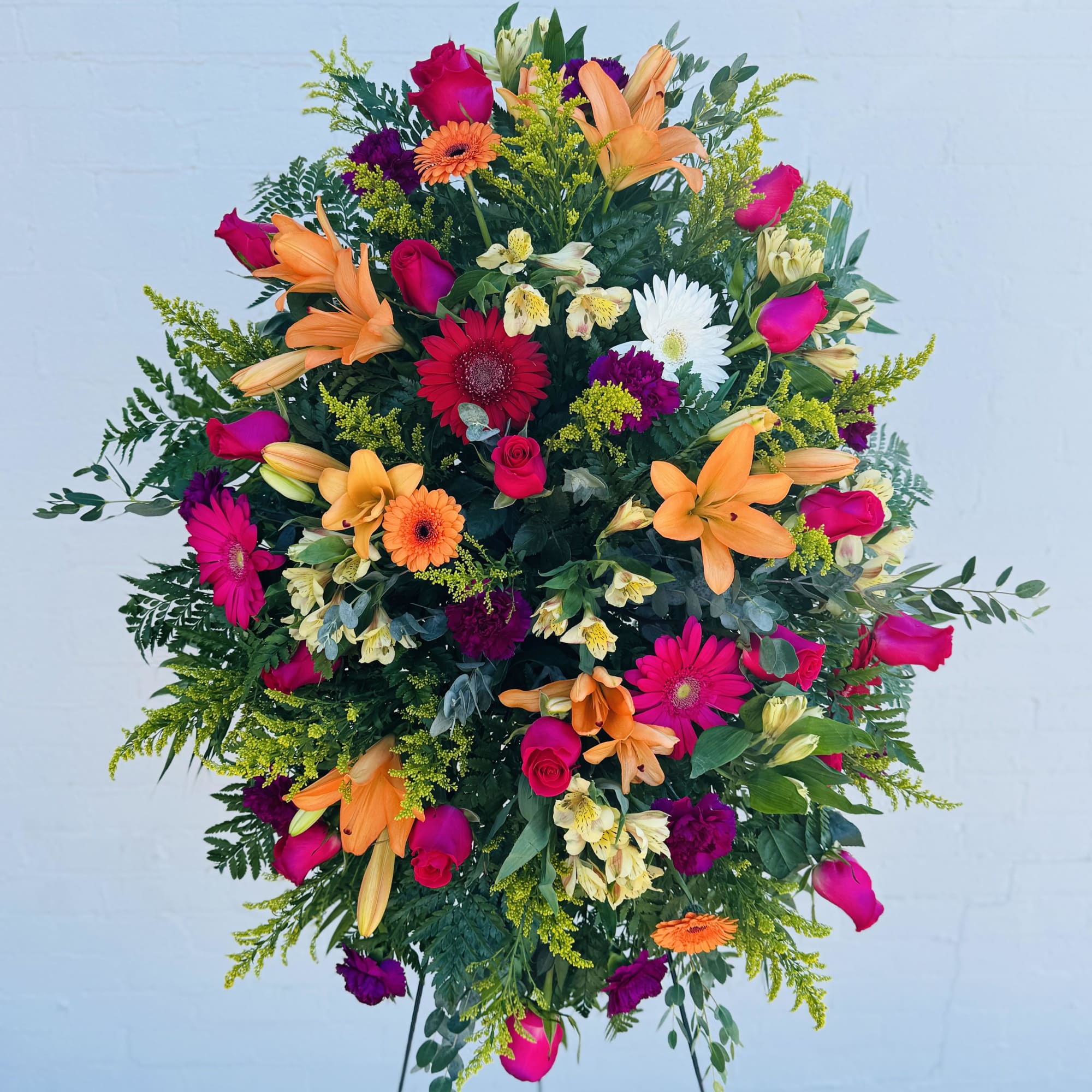 Large standing spray of mixed flowers in pink, orange, white, and purple