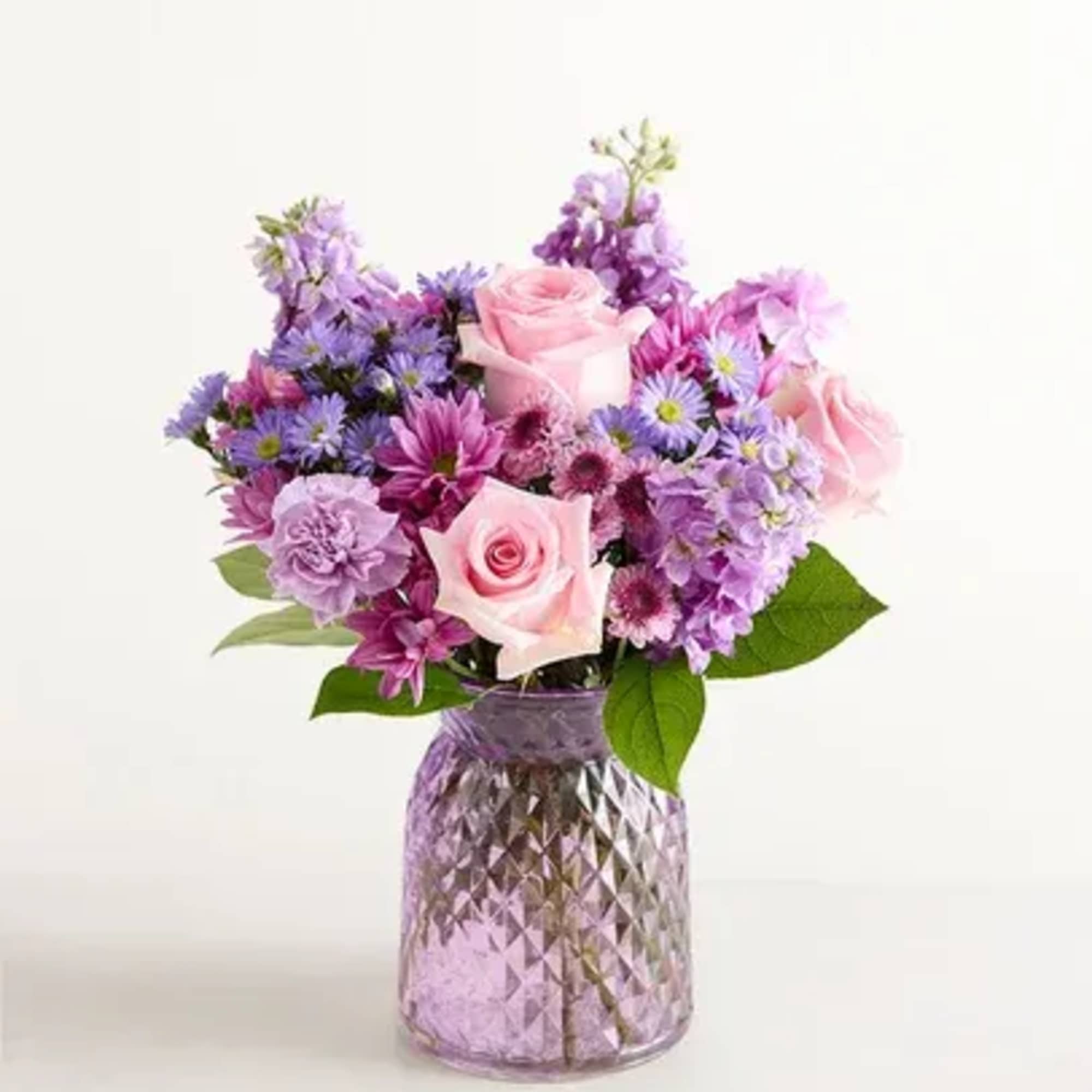 Purple vase, pink roses, lavender carnations, lavender daisies, purple monte, lavender stock