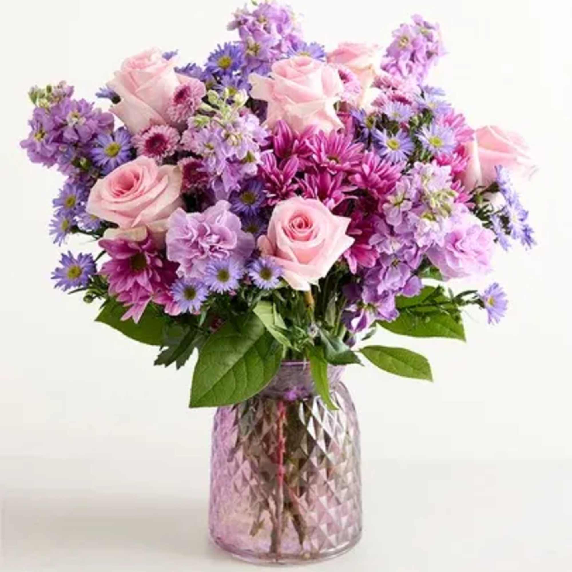 Purple vase, pink roses, lavender carnations, lavender daisies, purple monte, lavender stock