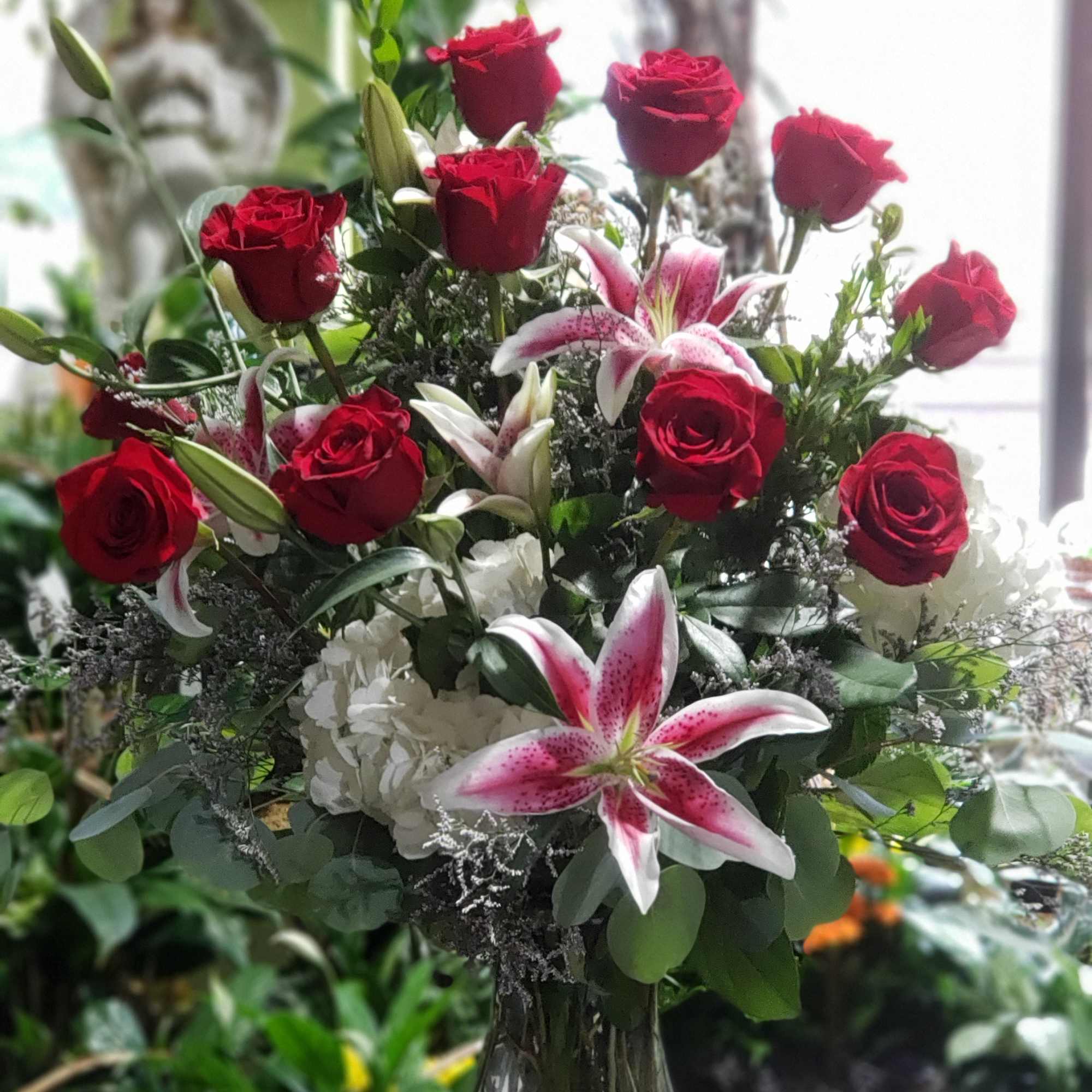 Featuring brilliant stargazer lilies and a dozen red roses is sure to