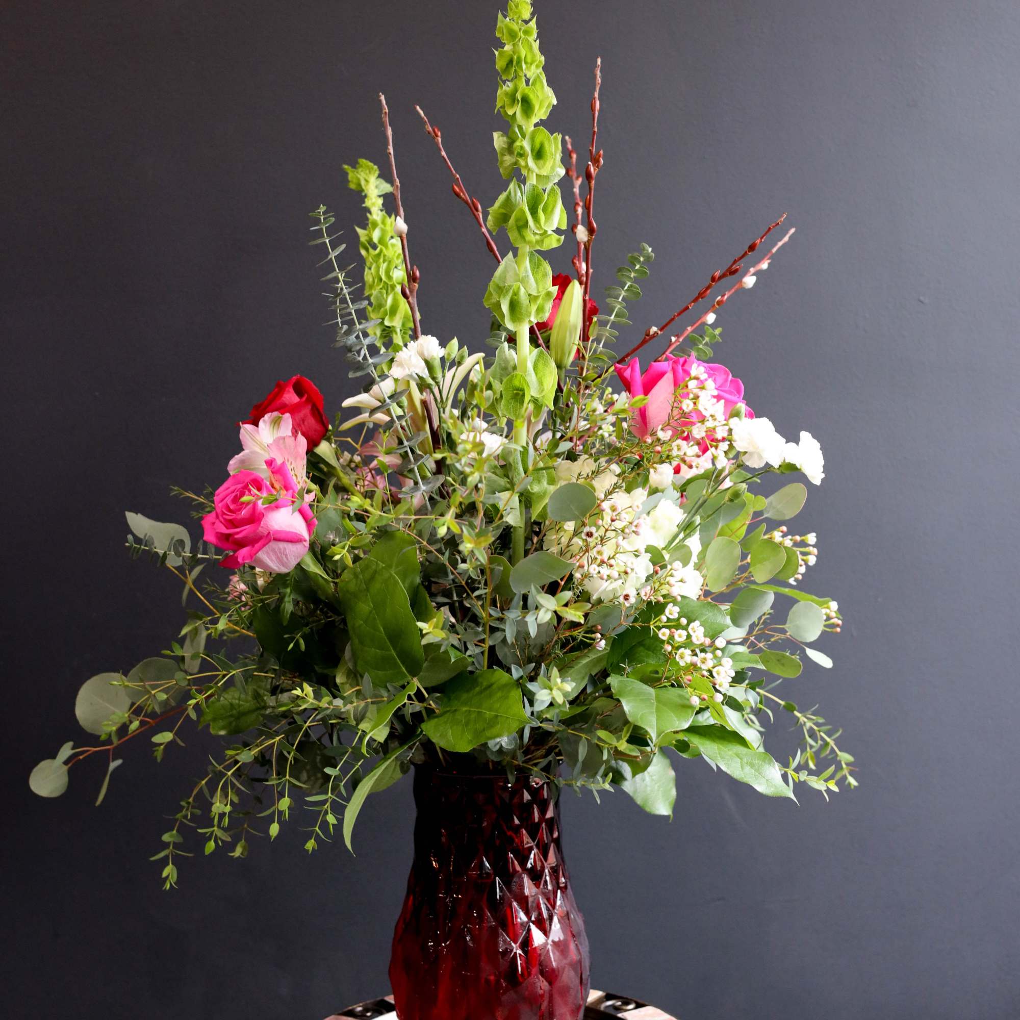 A lush airy arrangement filled with Roses, Lilies, Alstroemeria, Bells of Ireland