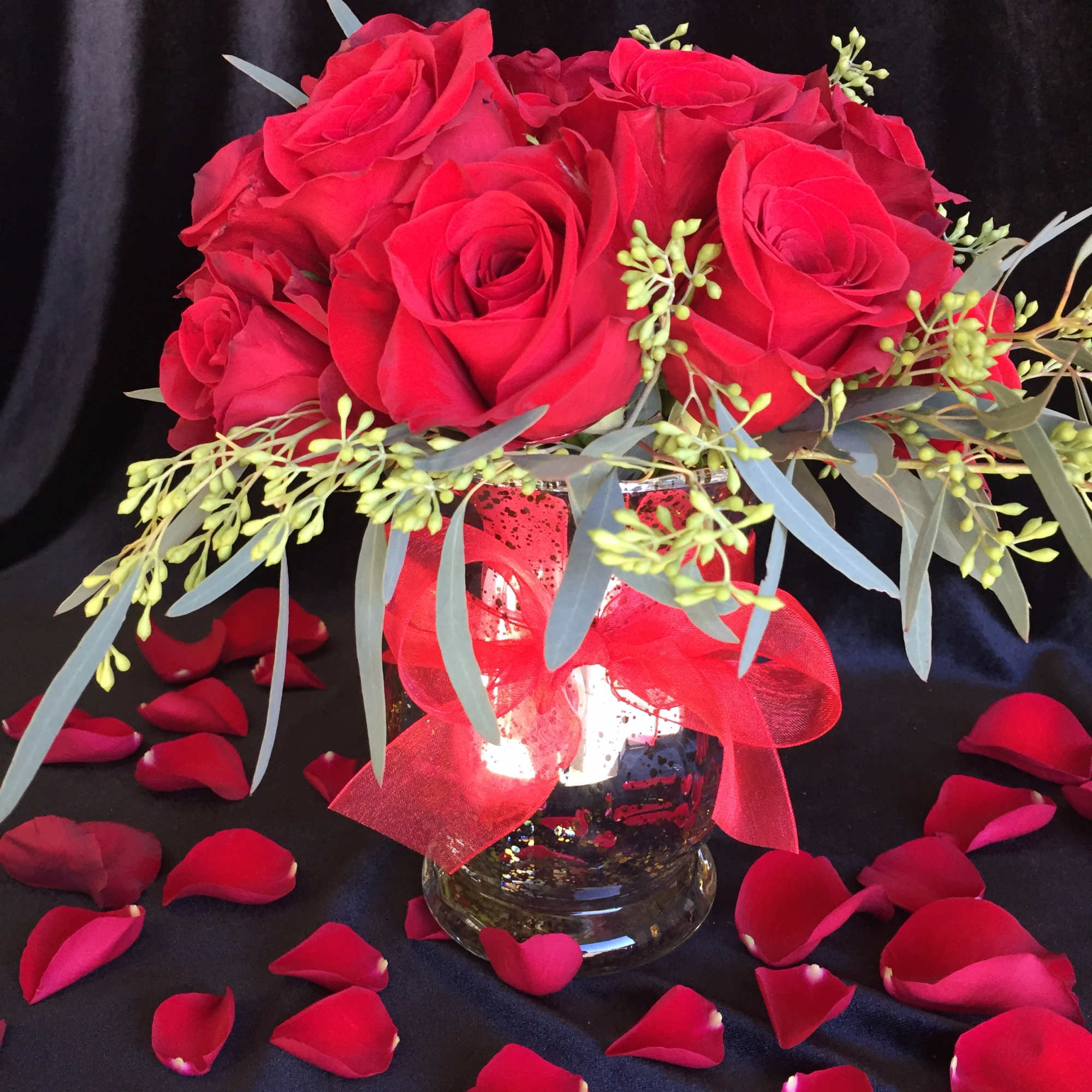 Red roses styled low and lush with accents of greenery. 

* it's