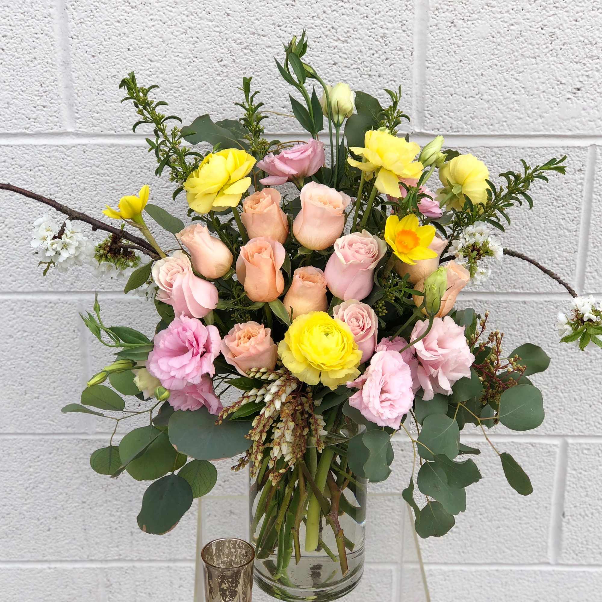 Mixed bouquet of pink and yellow flowers in a glass vase