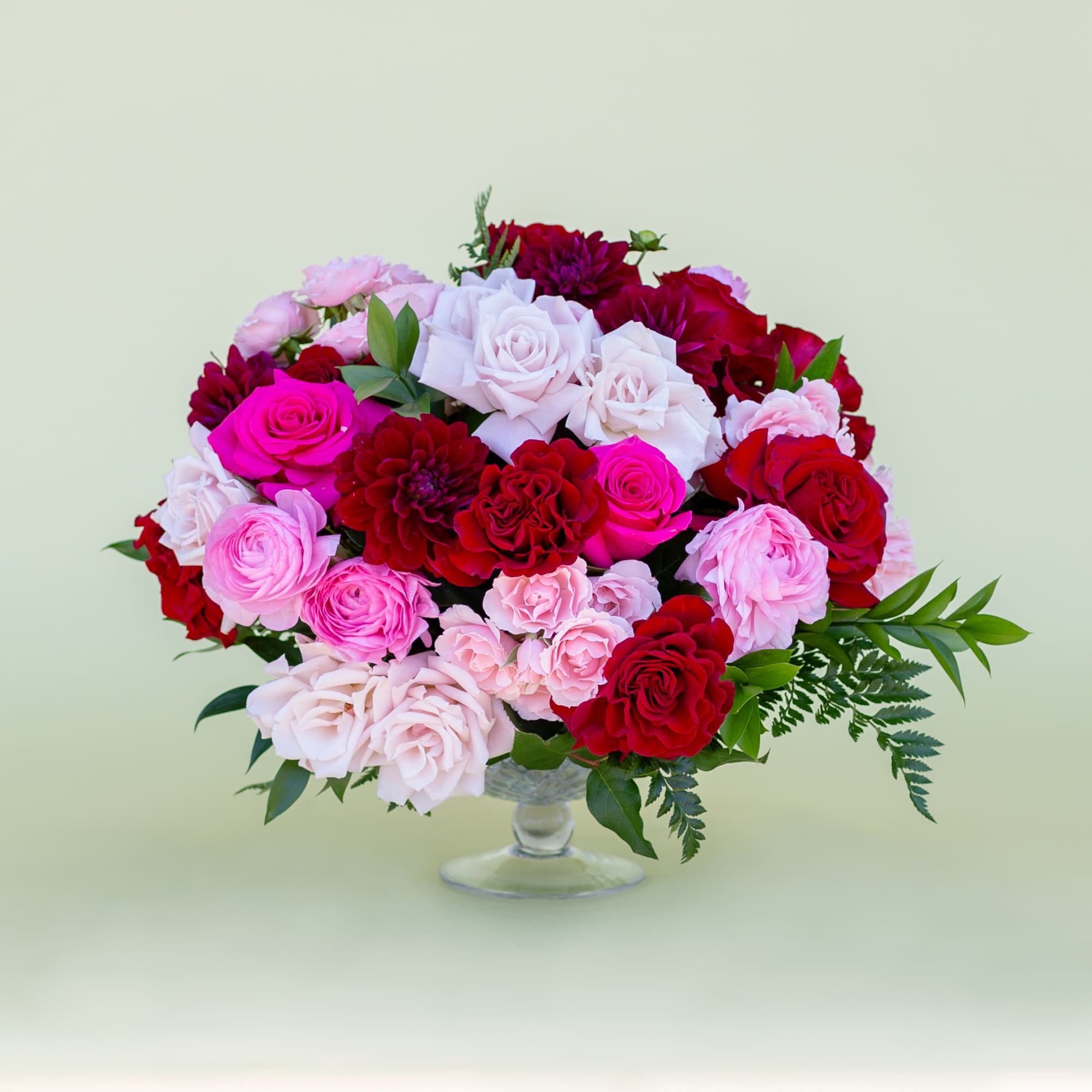 Bouquet of red, pink, and white roses in a clear glass vase