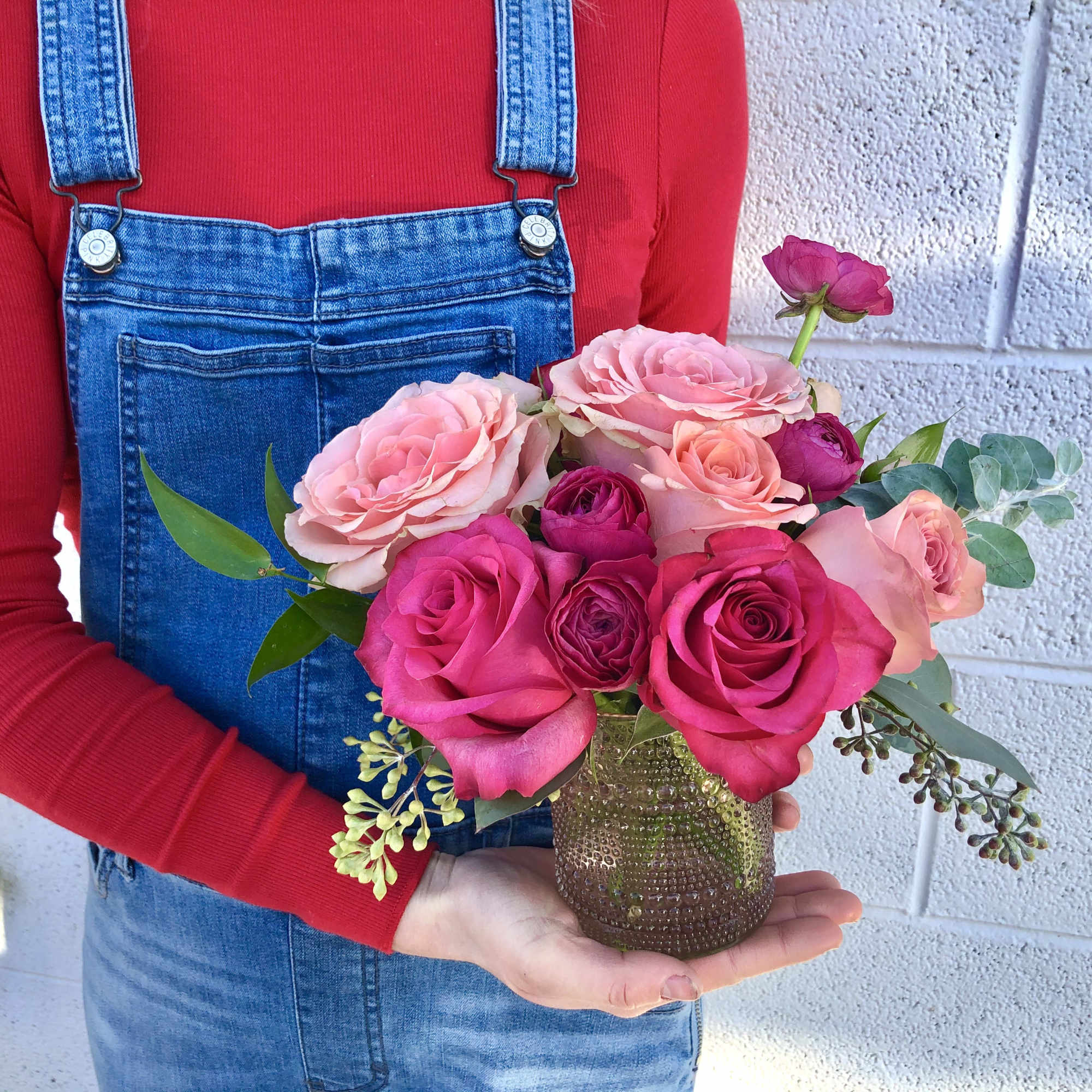 Pink and peach roses arranged in a small textured vase