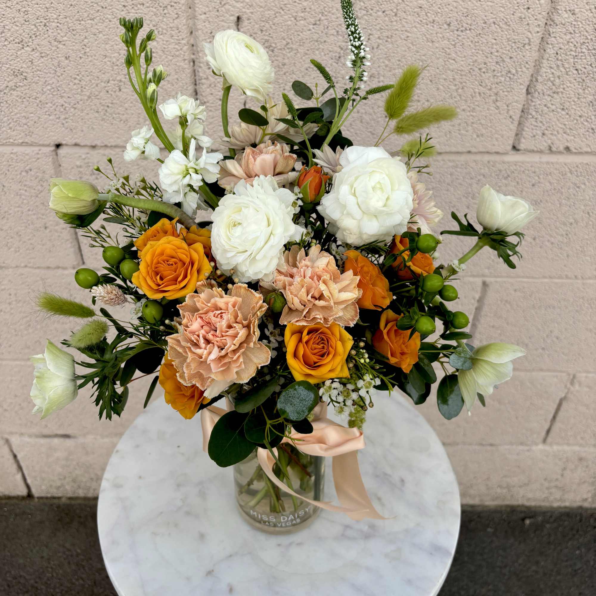 Bouquet of orange and white roses in a glass vase