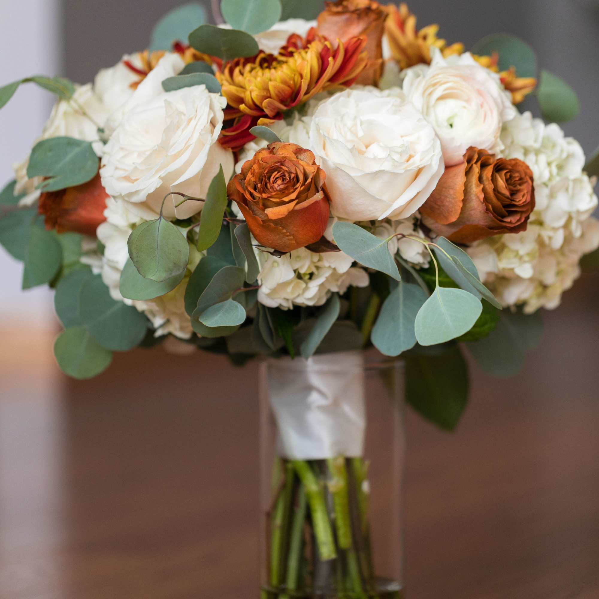 Bouquet of white and orange roses in a clear glass vase