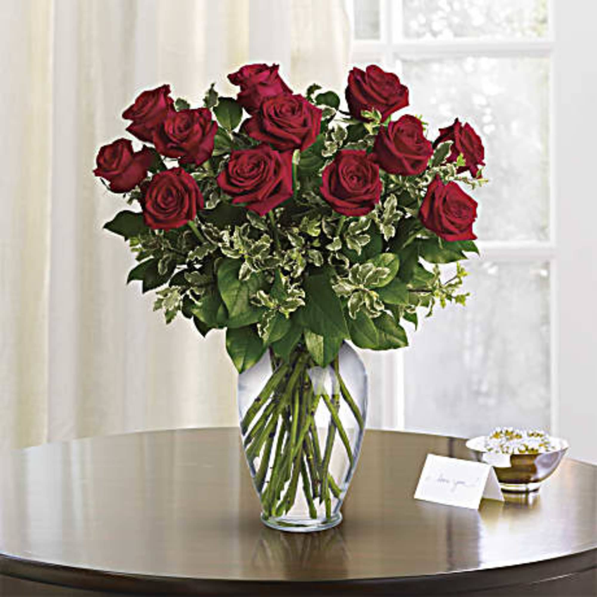 Red roses arranged in a clear glass vase