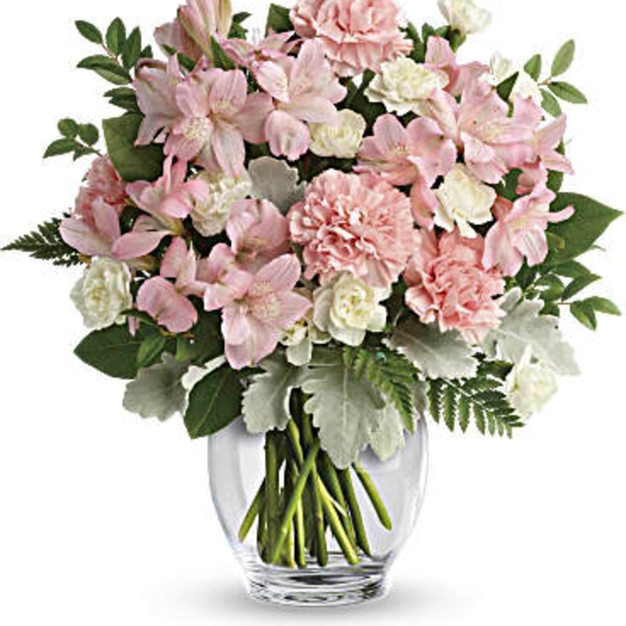 Pink and white flowers arranged in a clear glass vase