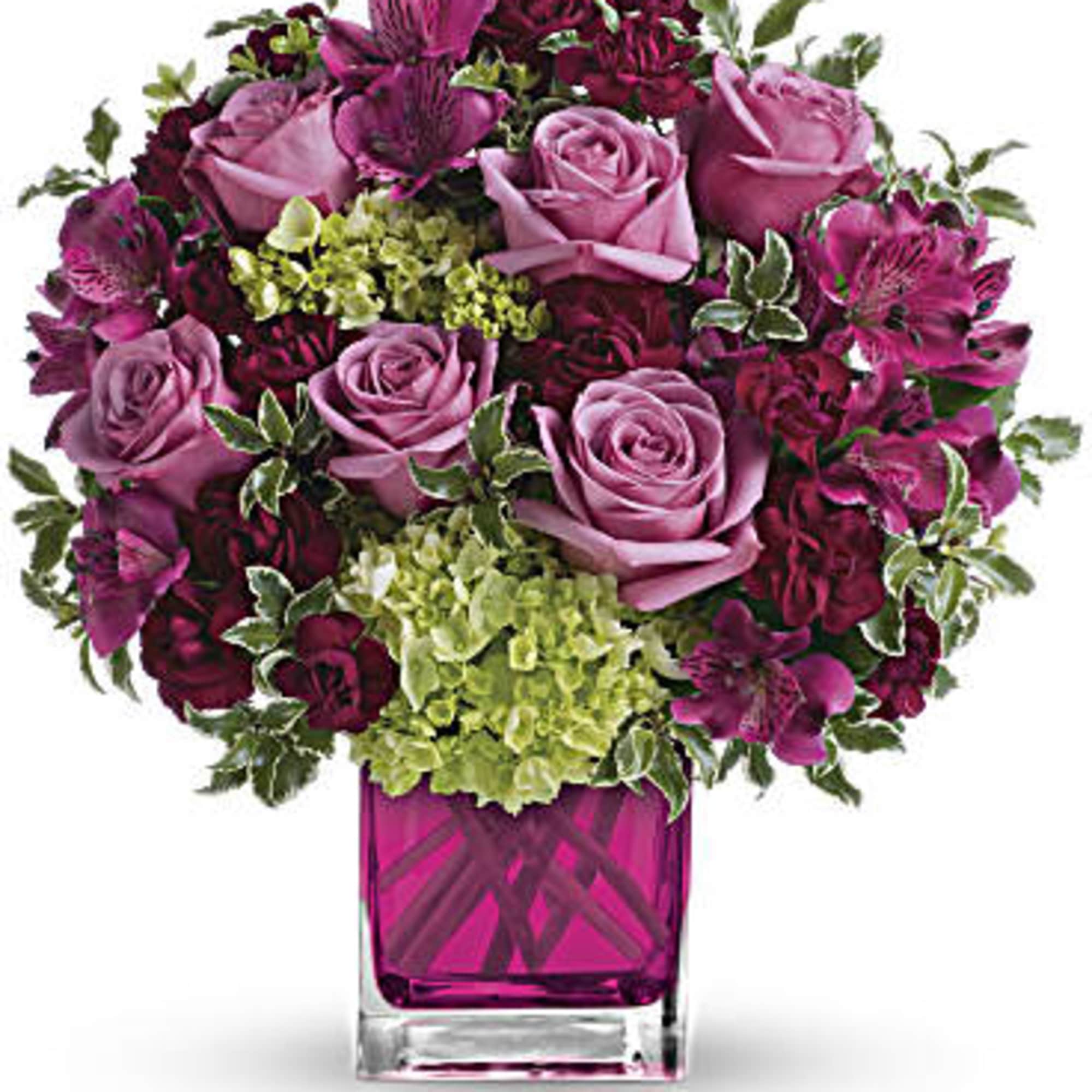 Pink and burgundy flower arrangement in a magenta glass vase