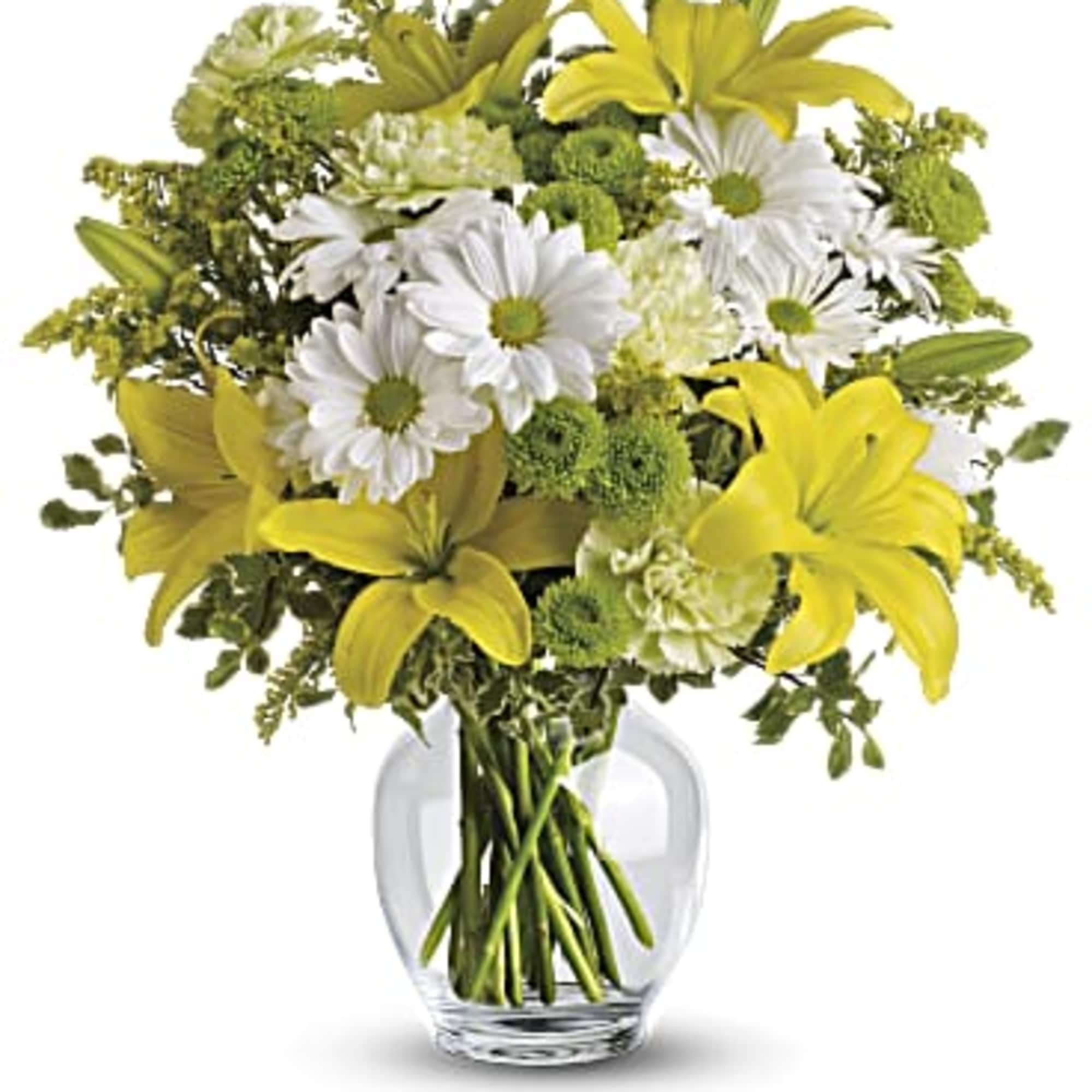 Yellow lilies and white daisies in a clear glass vase