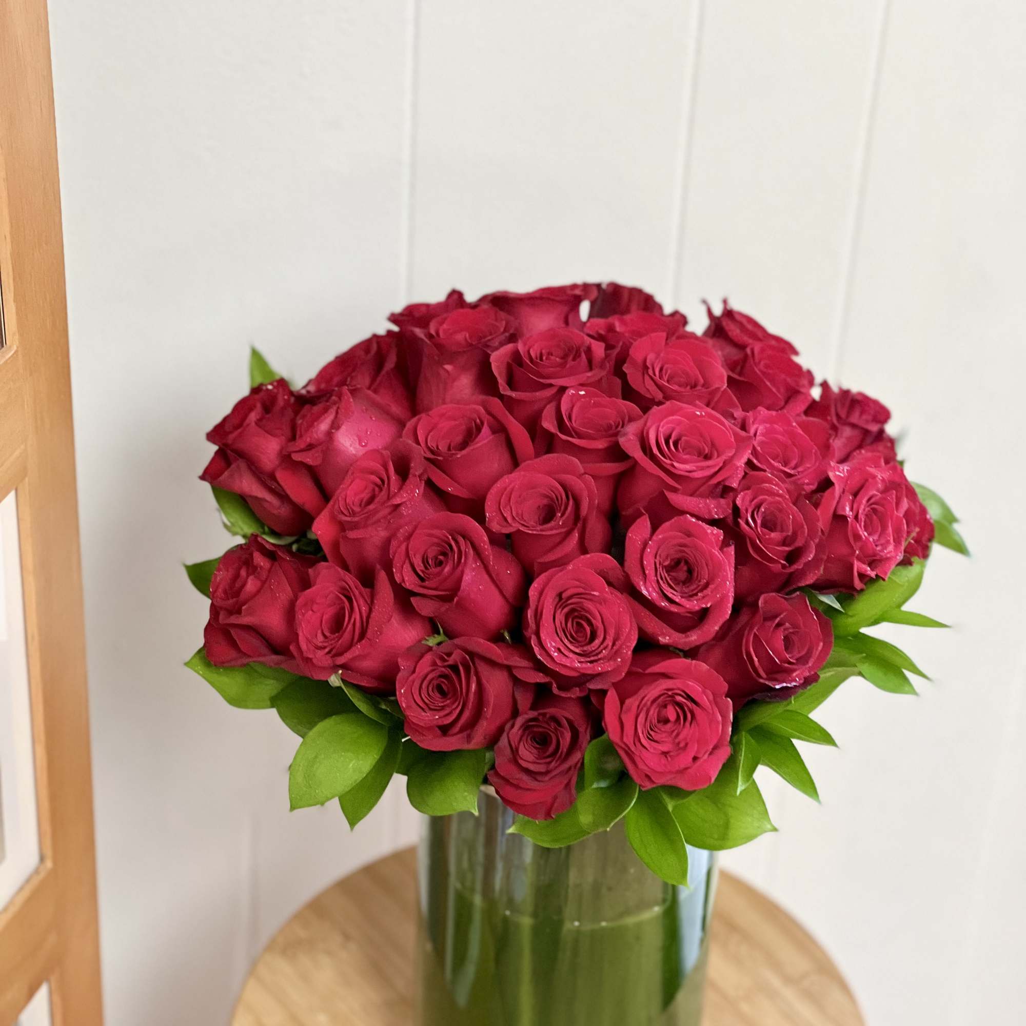Red rose bouquet in a tall glass vase
