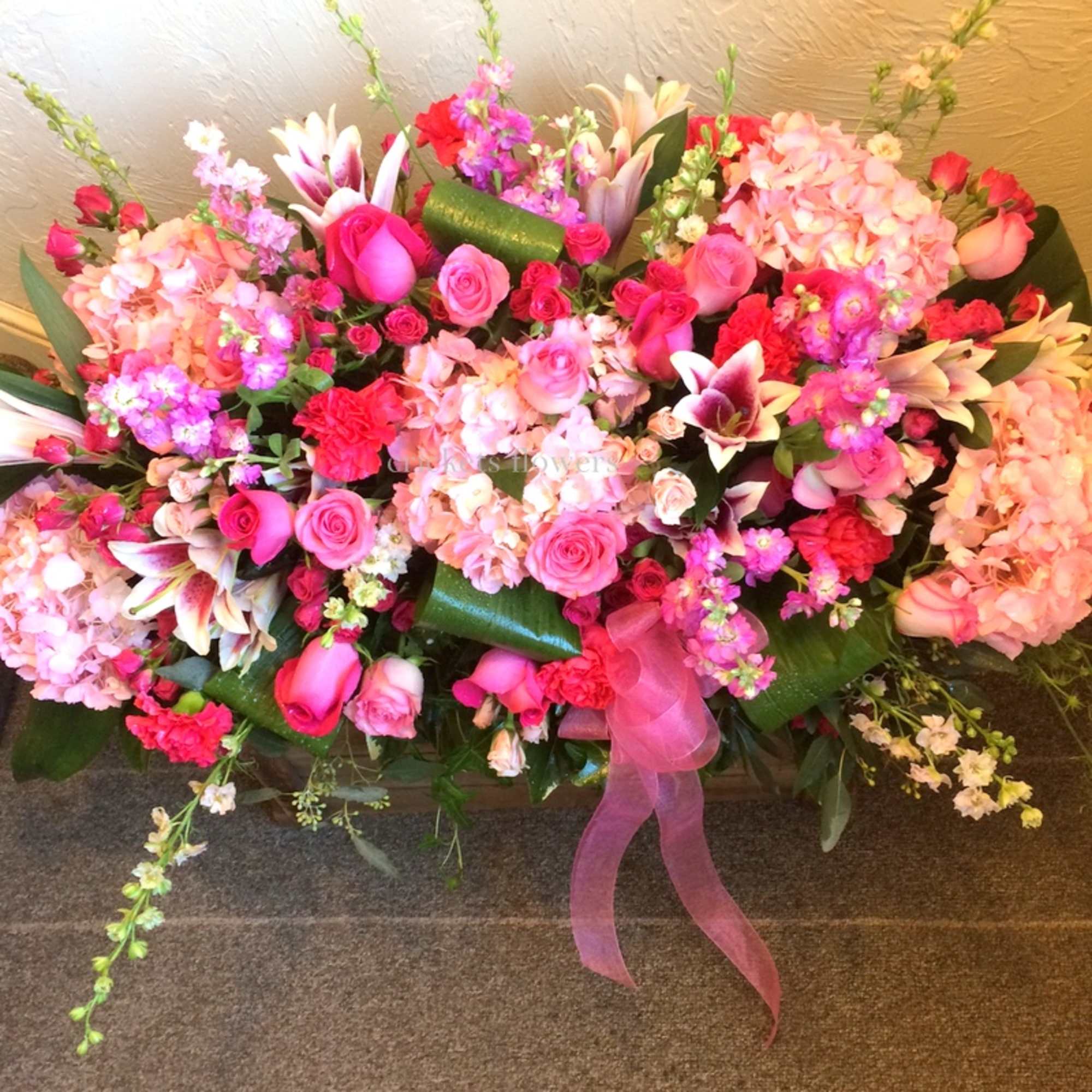 Large pink floral arrangement with roses, lilies, and hydrangeas