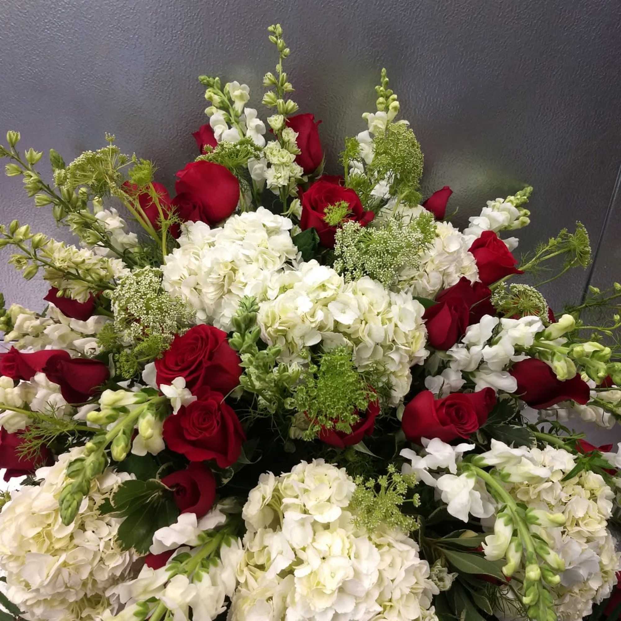 Red roses and white hydrangeas arranged in a large bouquet
