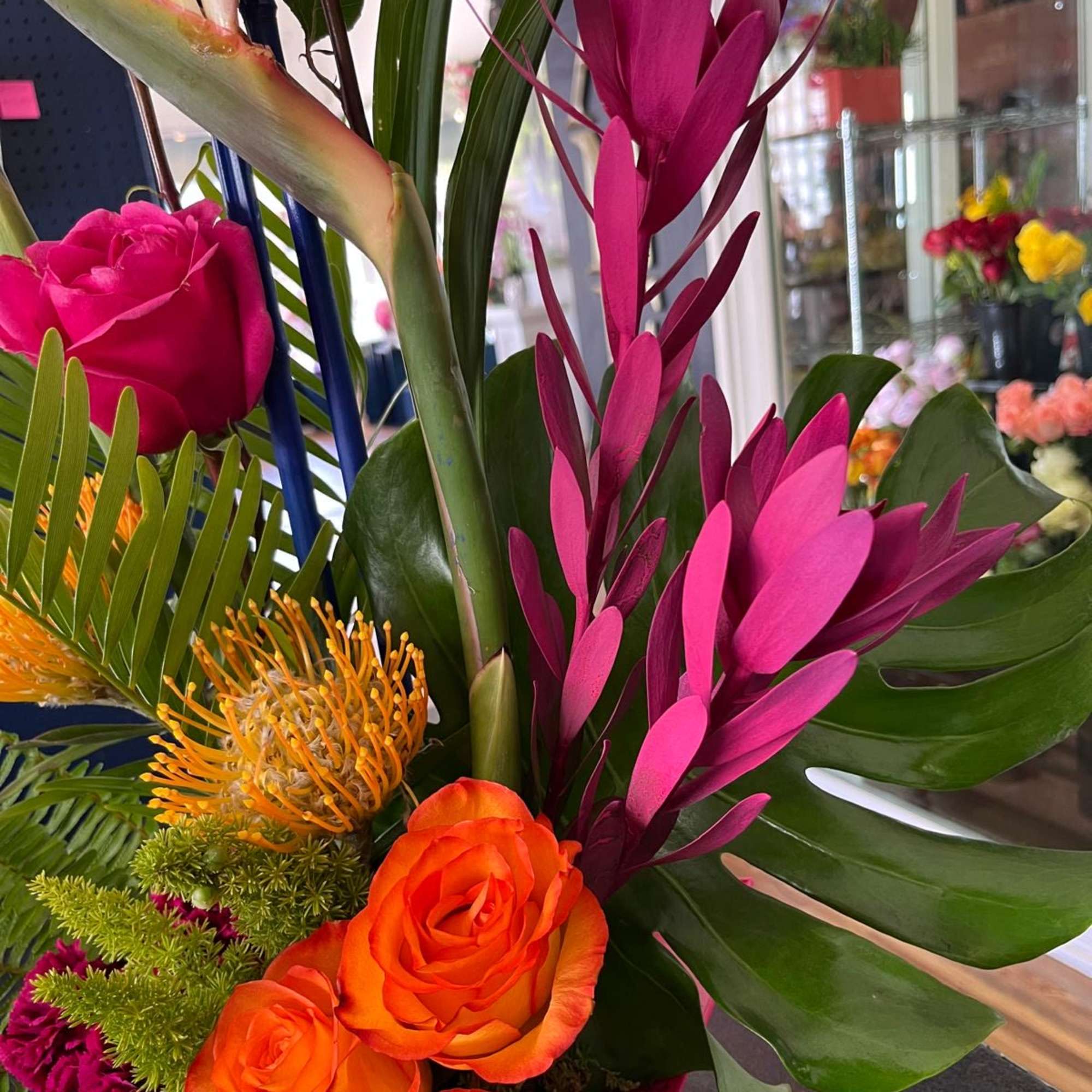 Tropical bouquet with orange roses and bright pink flowers