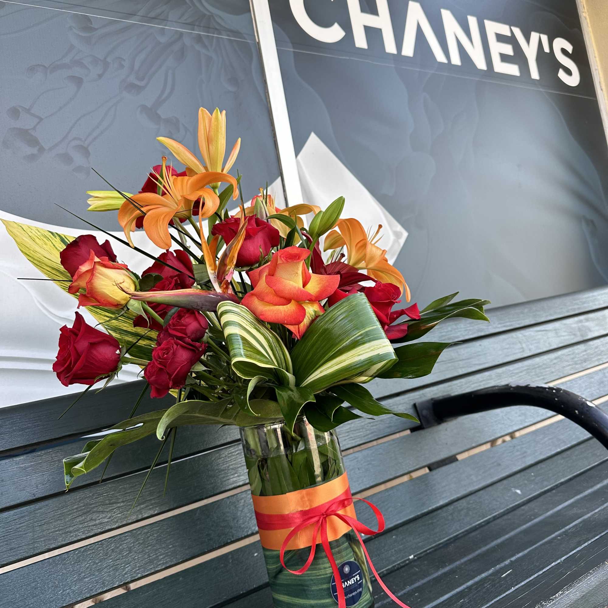 Bouquet of red roses and orange lilies in a glass vase