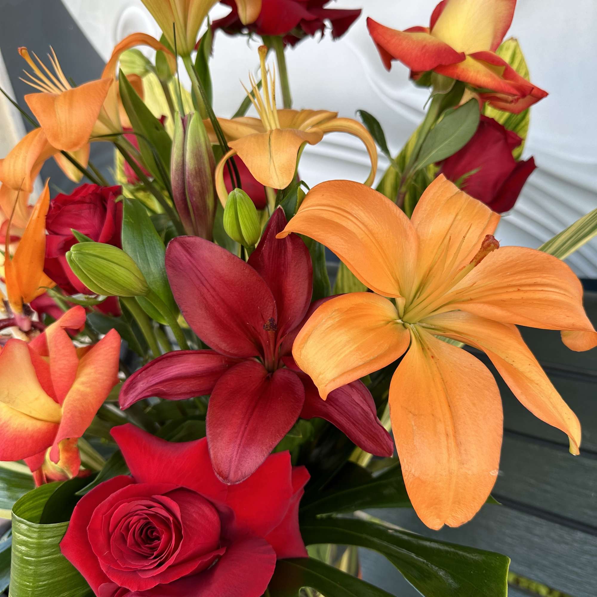 Bouquet of orange and red lilies with red roses