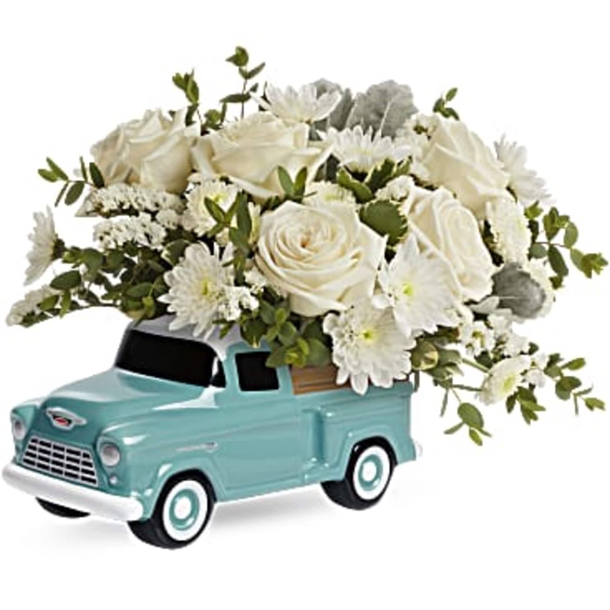 White floral arrangement in a turquoise toy truck