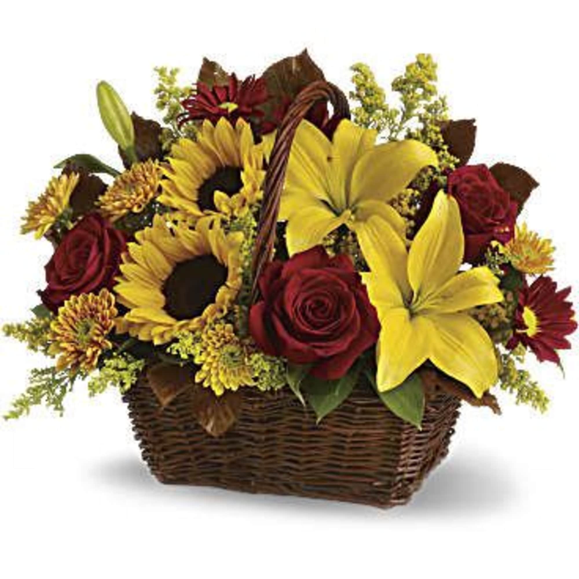 Basket arrangement with yellow lilies, red roses, and sunflowers