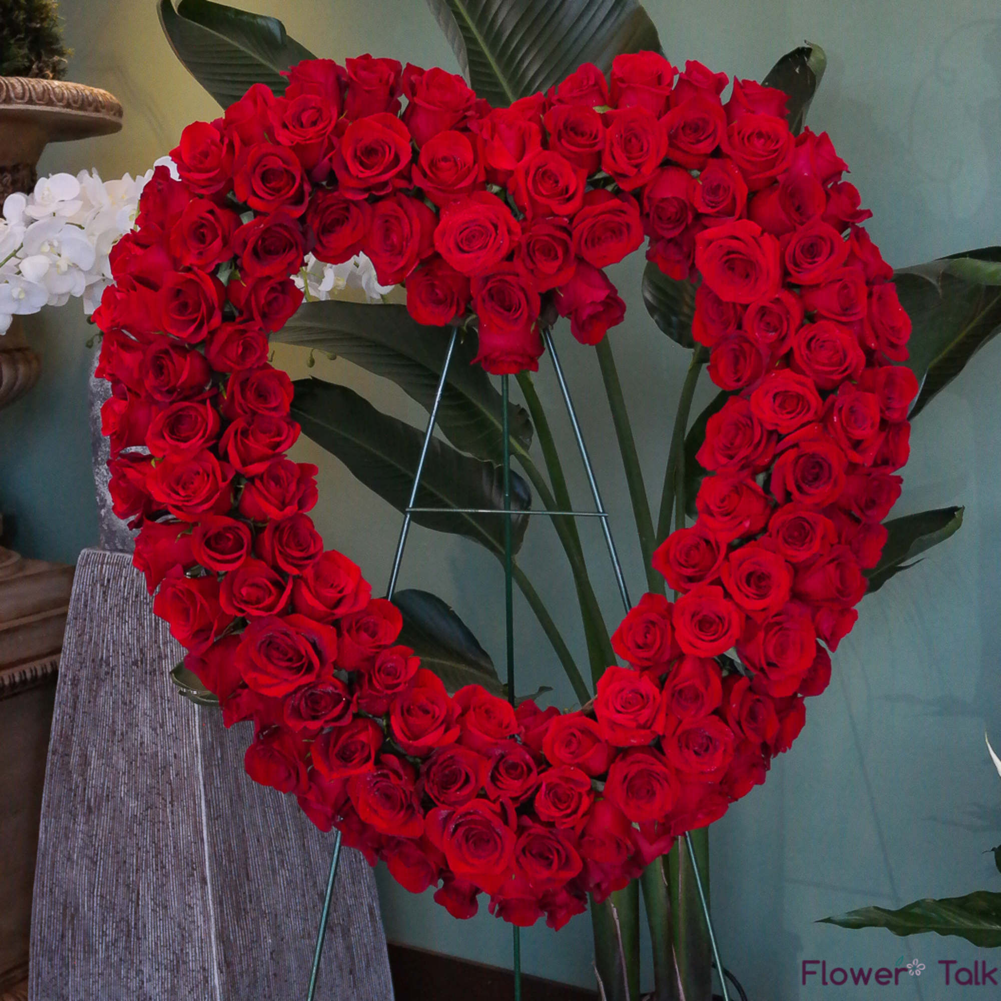 Heart-shaped arrangement of red roses on a stand