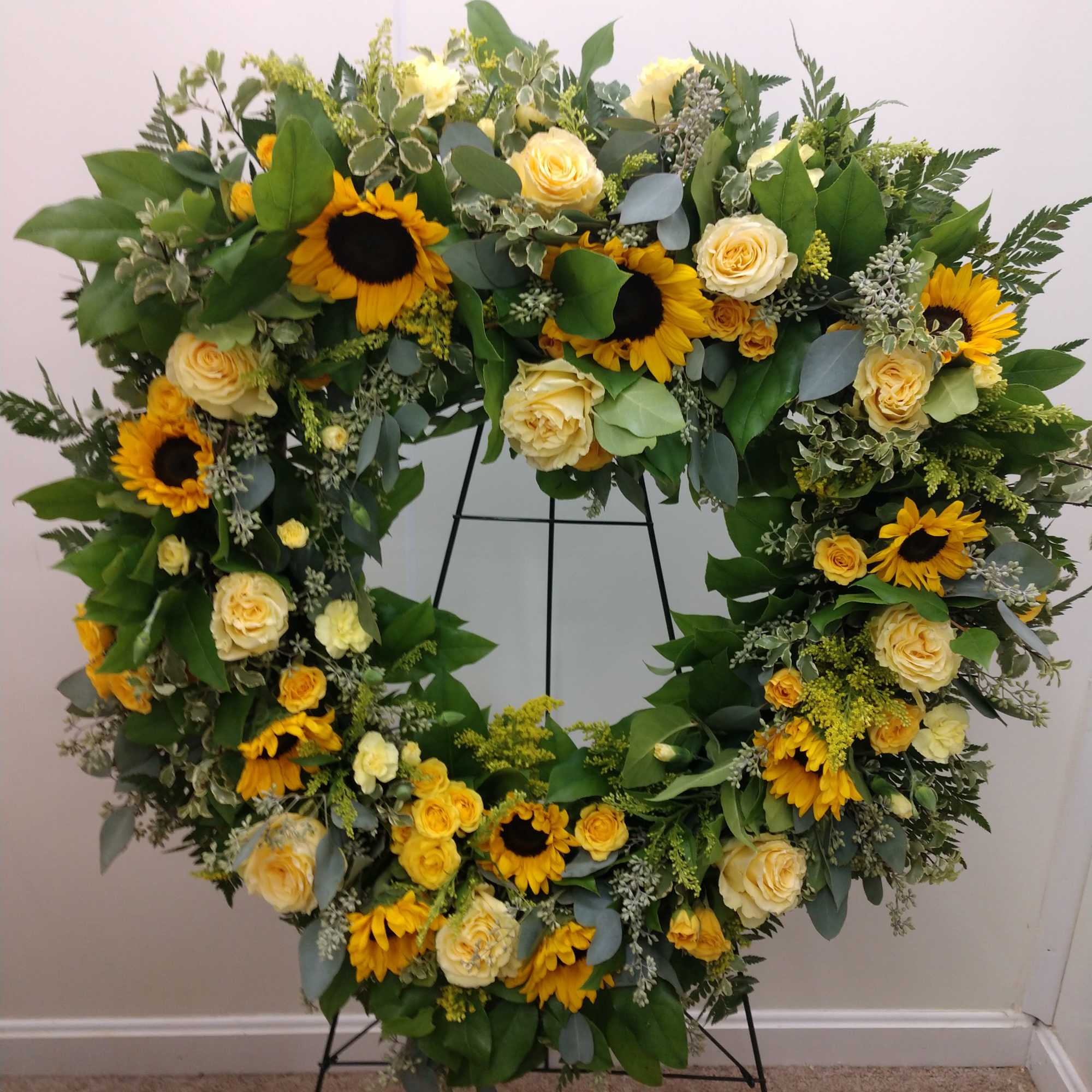 Large floral wreath with yellow sunflowers and cream roses