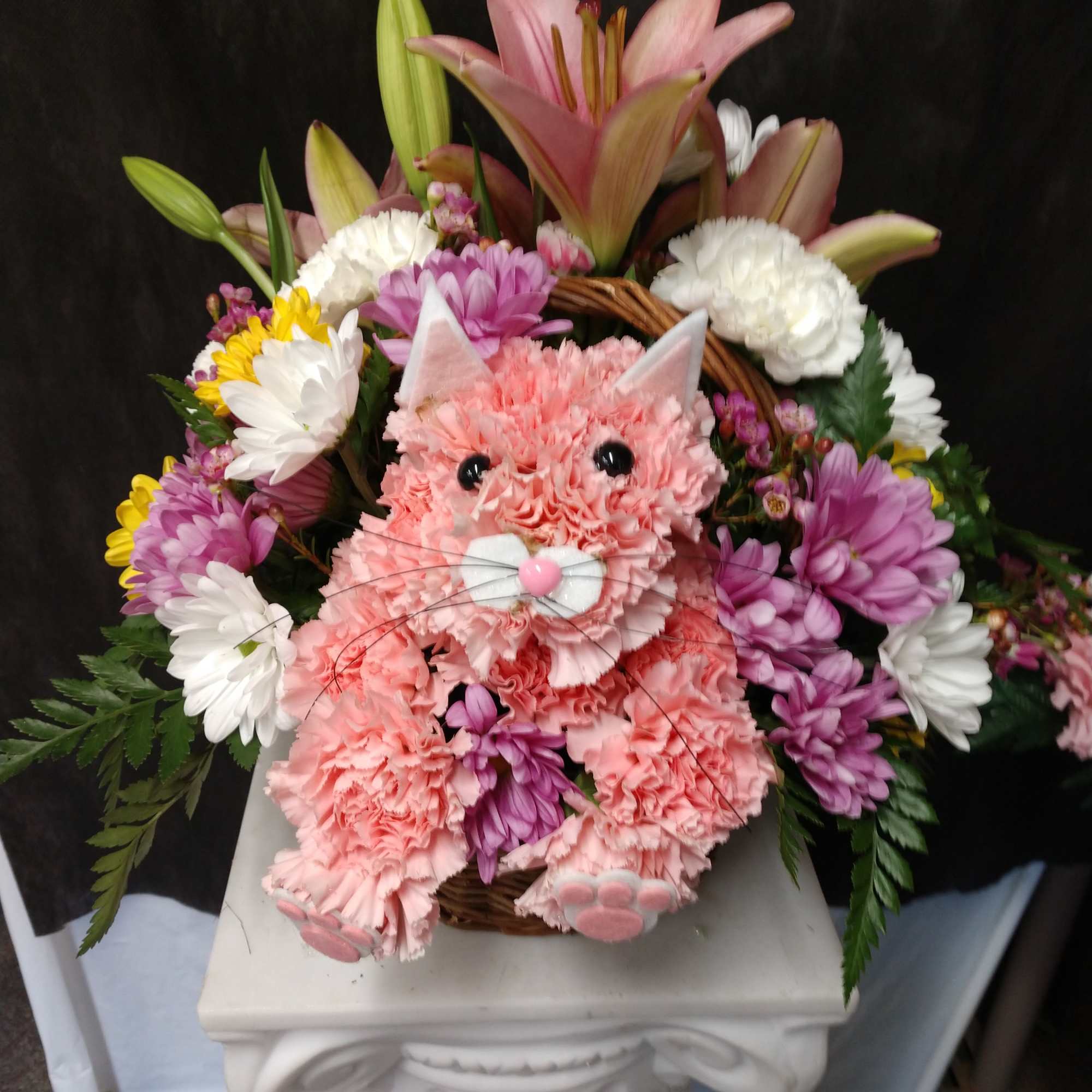 Pink cat-shaped floral basket with lilies and daisies