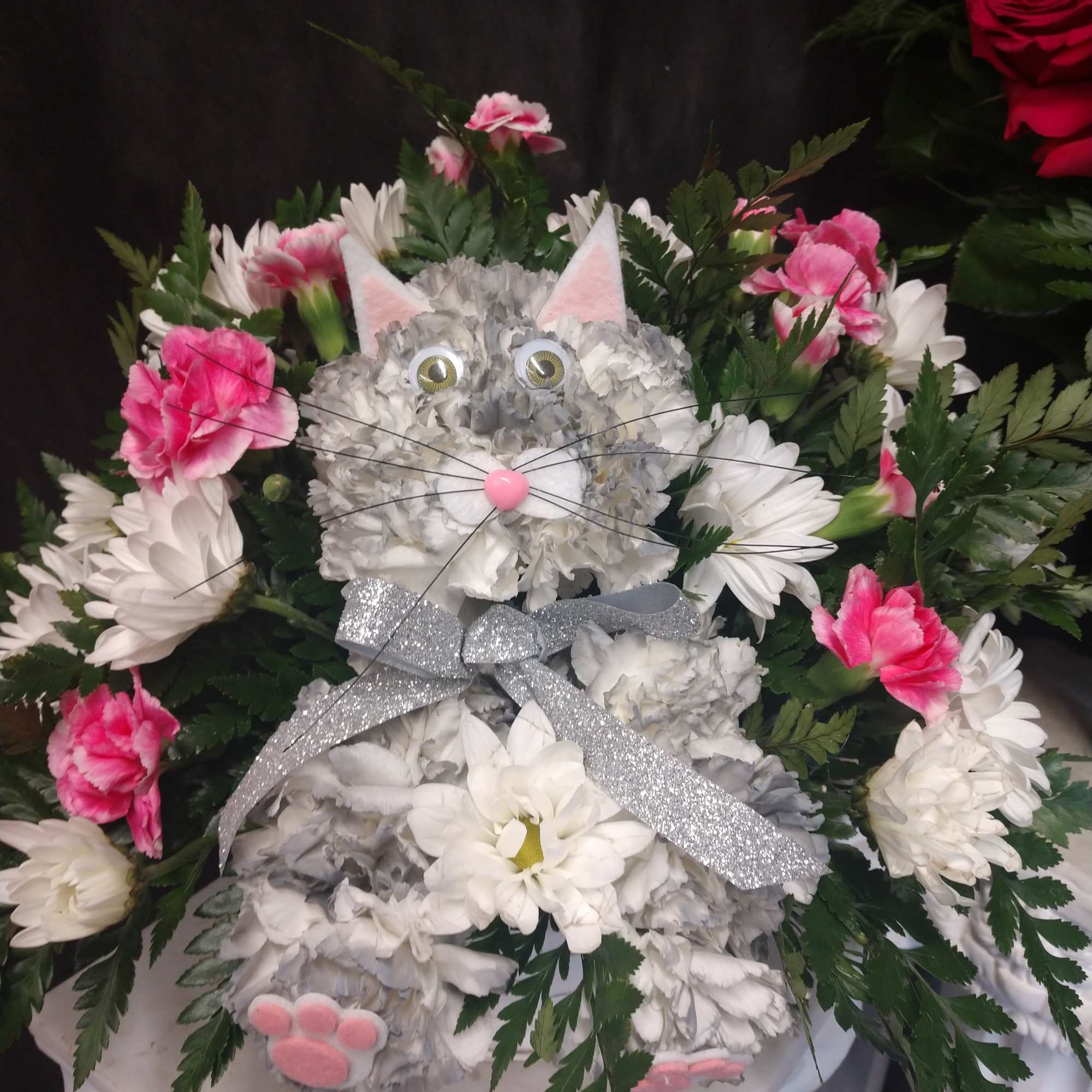 Cat-shaped floral arrangement with white and pink flowers and a silver bow