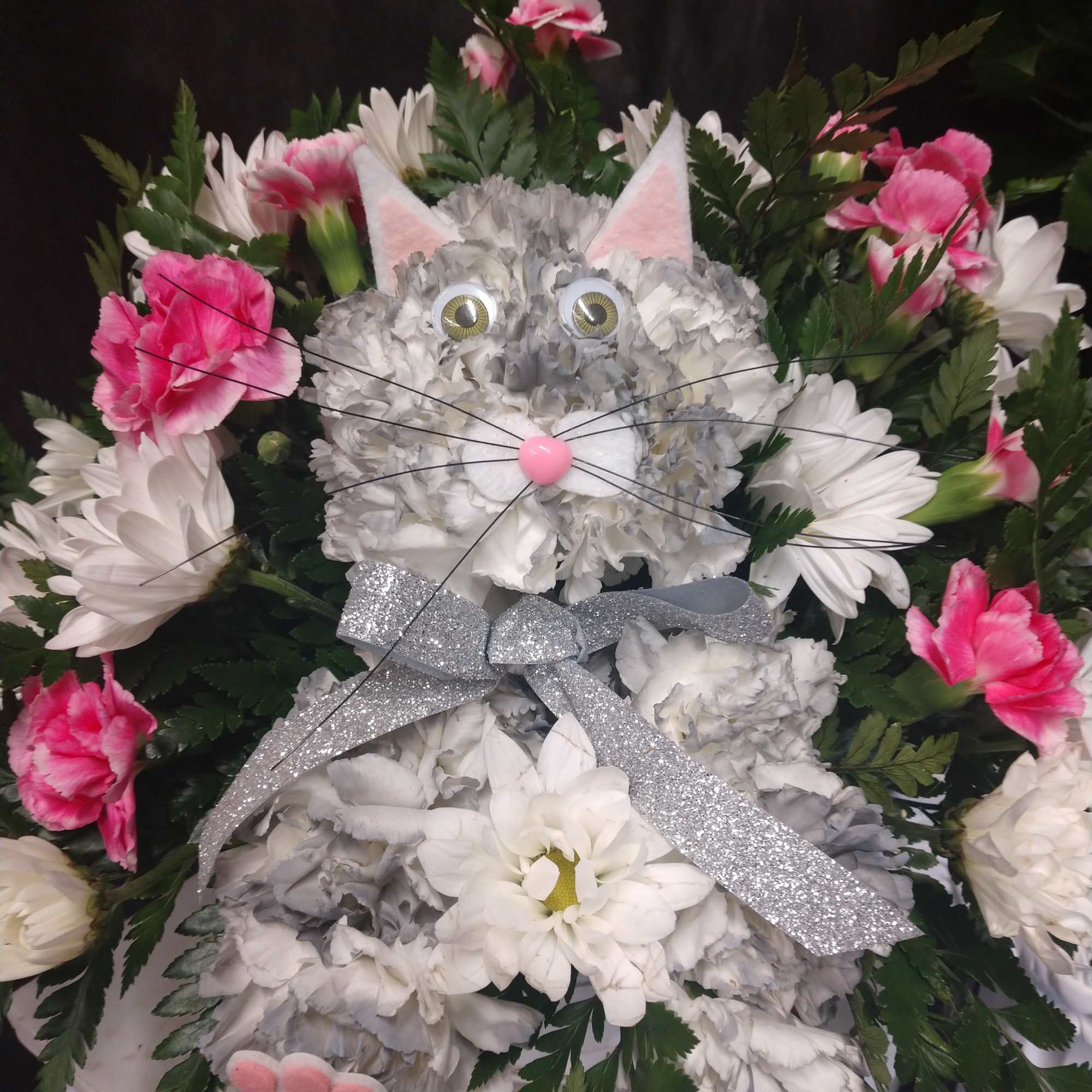 Cat-shaped floral arrangement with pink and white flowers and a silver bow