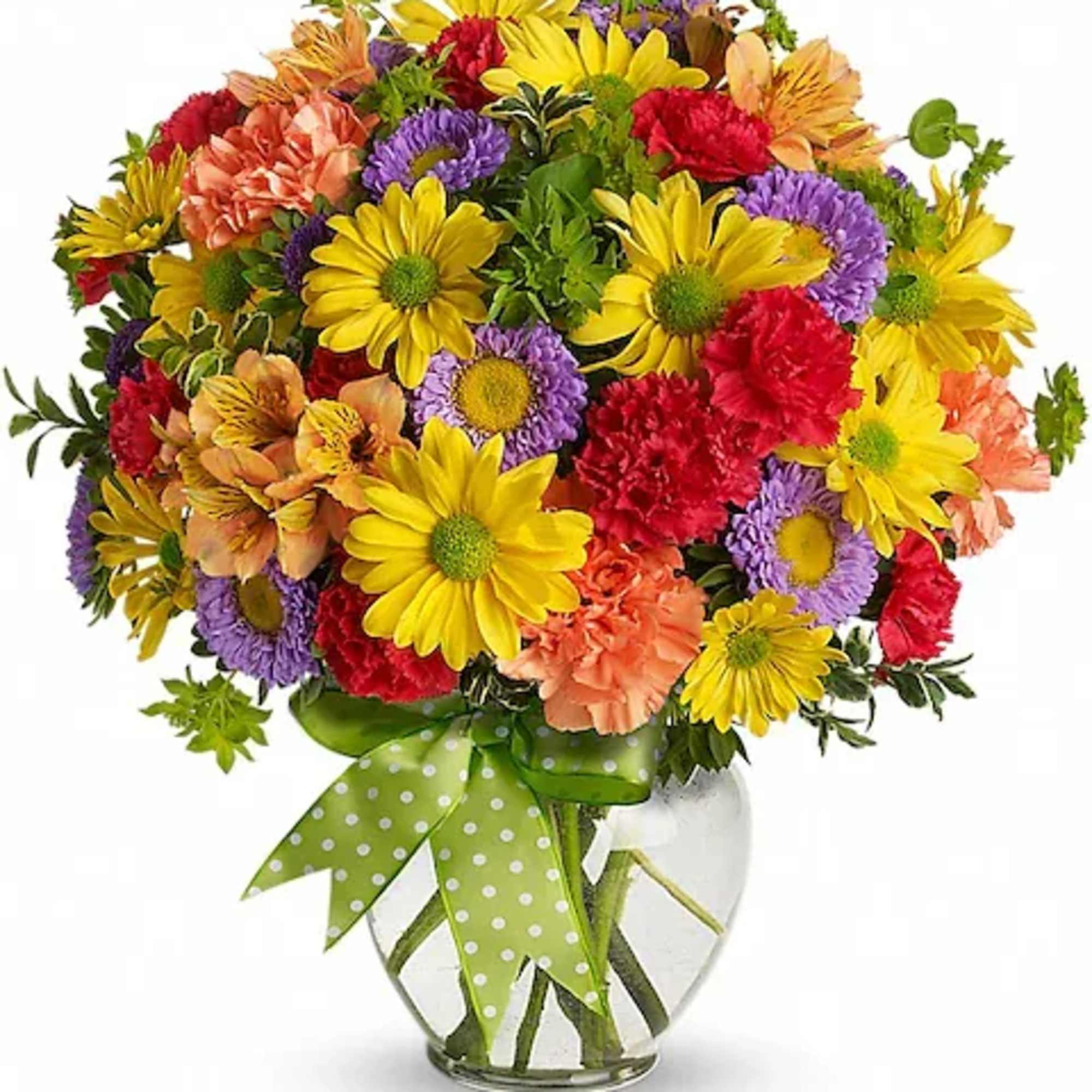 Colorful mixed bouquet in a glass vase with a green polka-dot ribbon