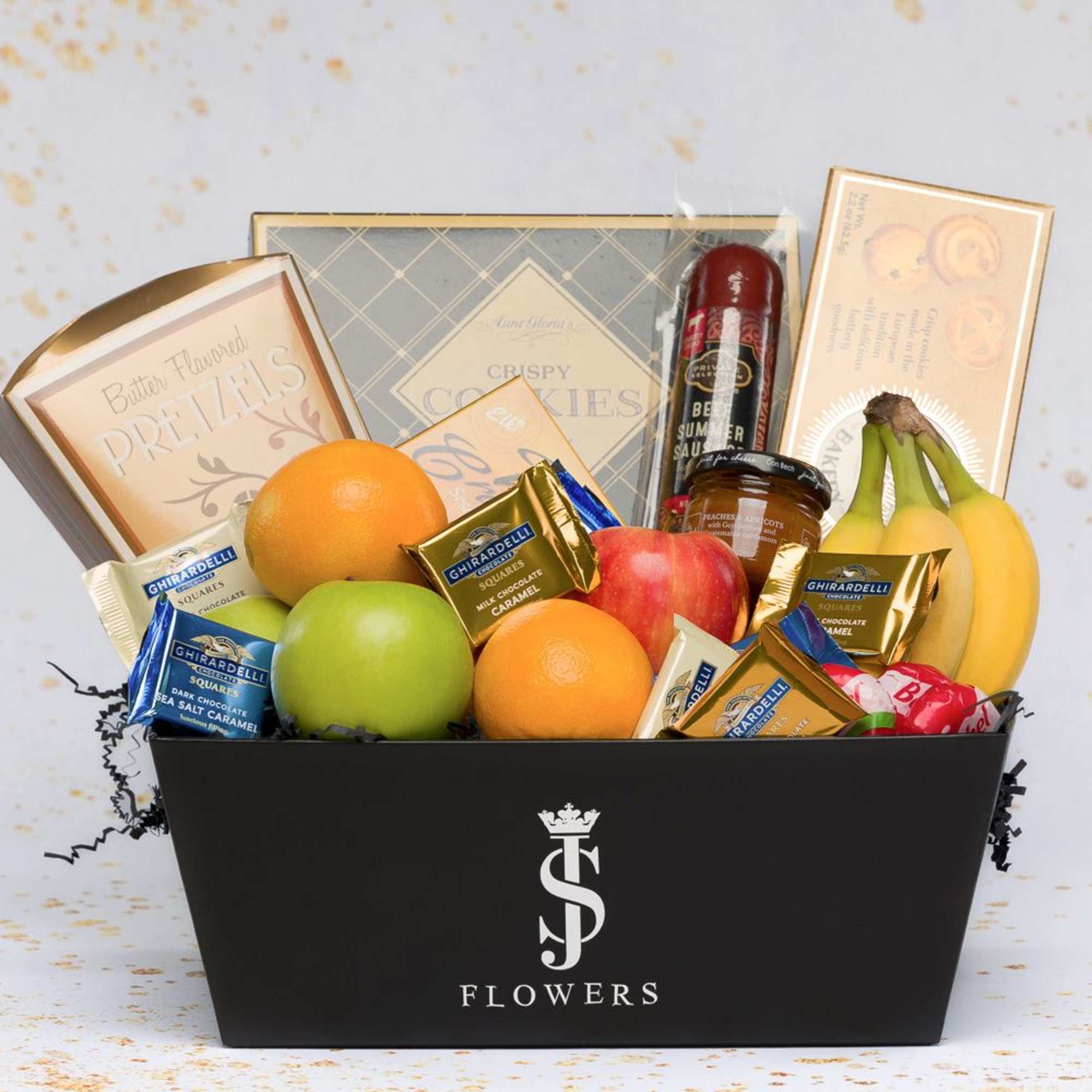 Gift basket with fruit, chocolates, cookies, and a bottle in a black box
