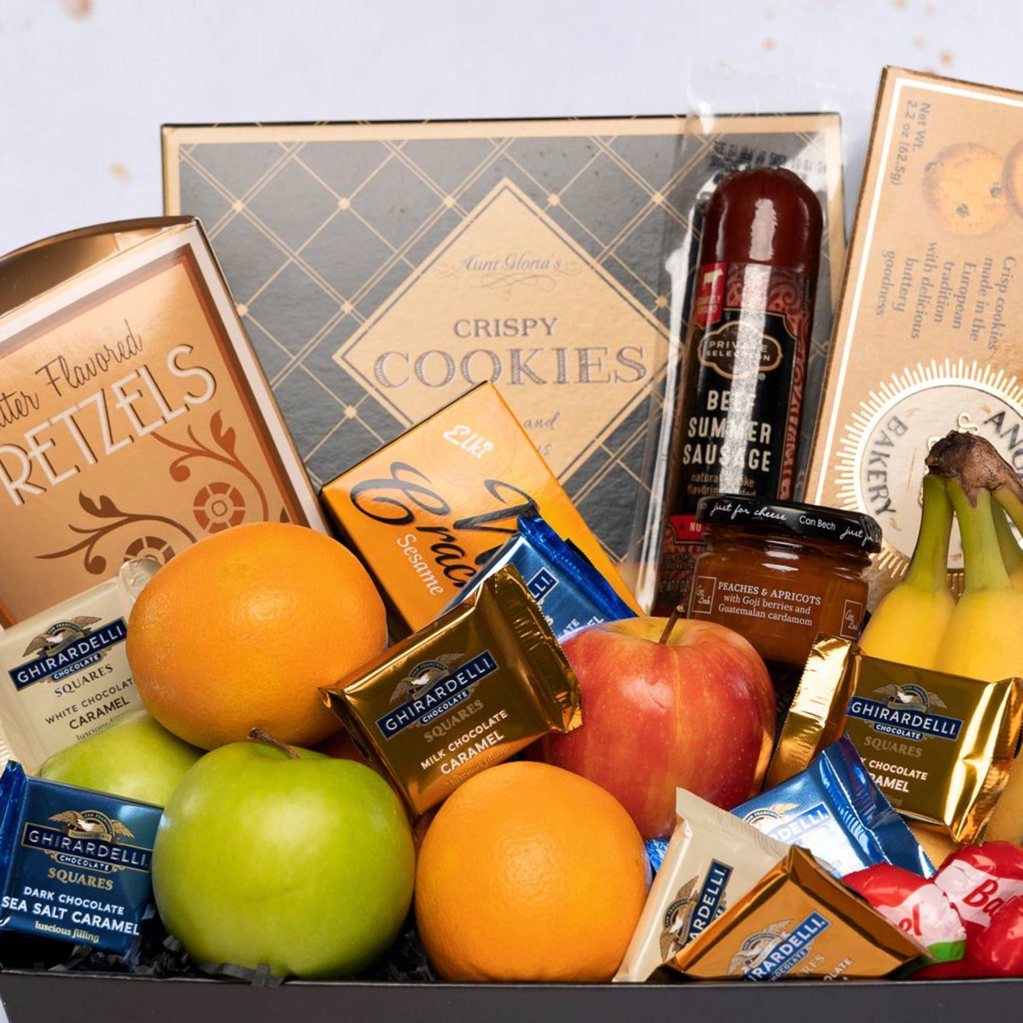 Gift basket with fruit, chocolates, cookies, pretzels, and sausage