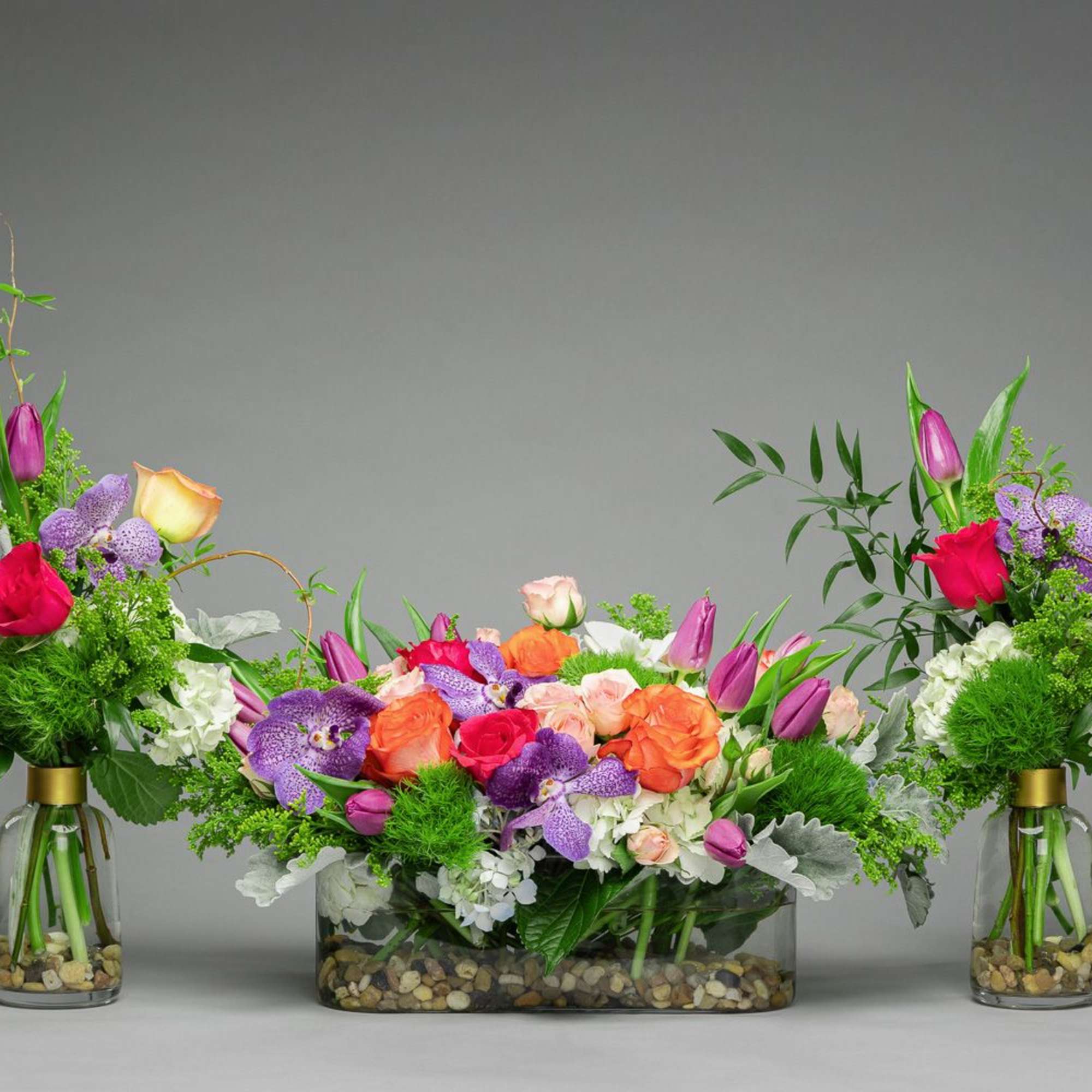 Colorful floral centerpiece with two matching vase arrangements