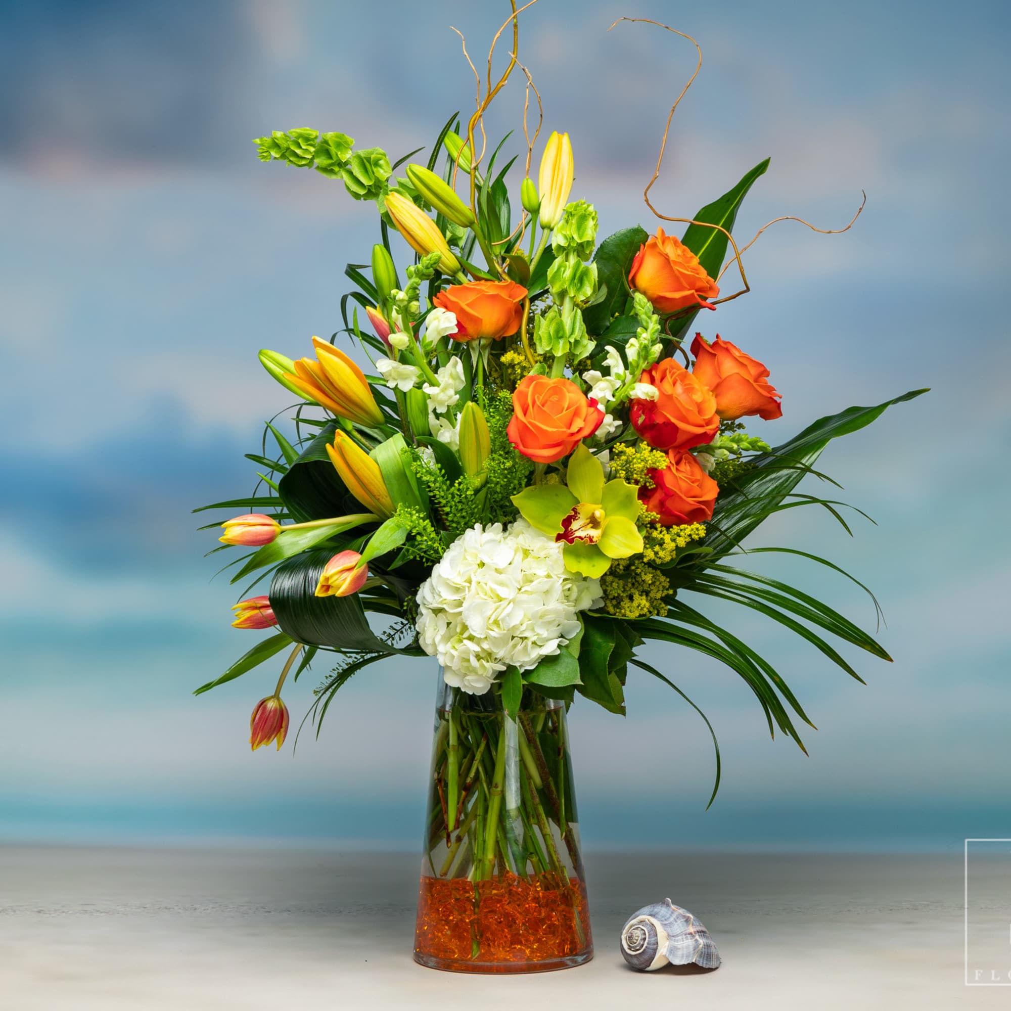 Citrus Summer Blossom is an elegant arrangement with Bells of Ireland, Lilies