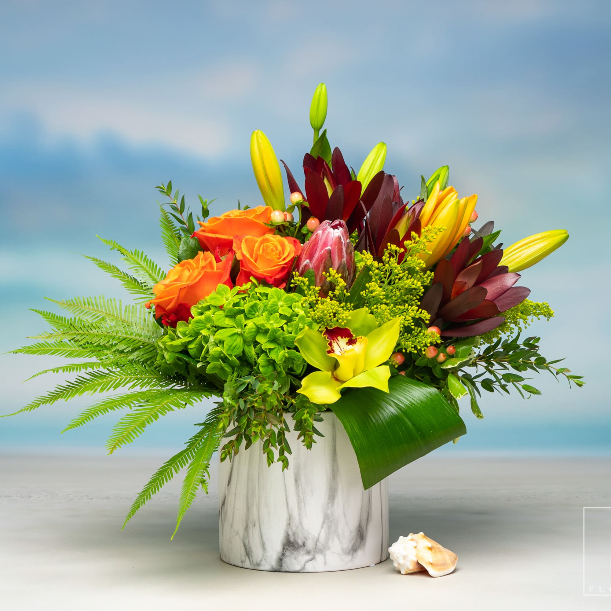 Bright mixed bouquet in a white marble vase with orange roses and yellow lilies