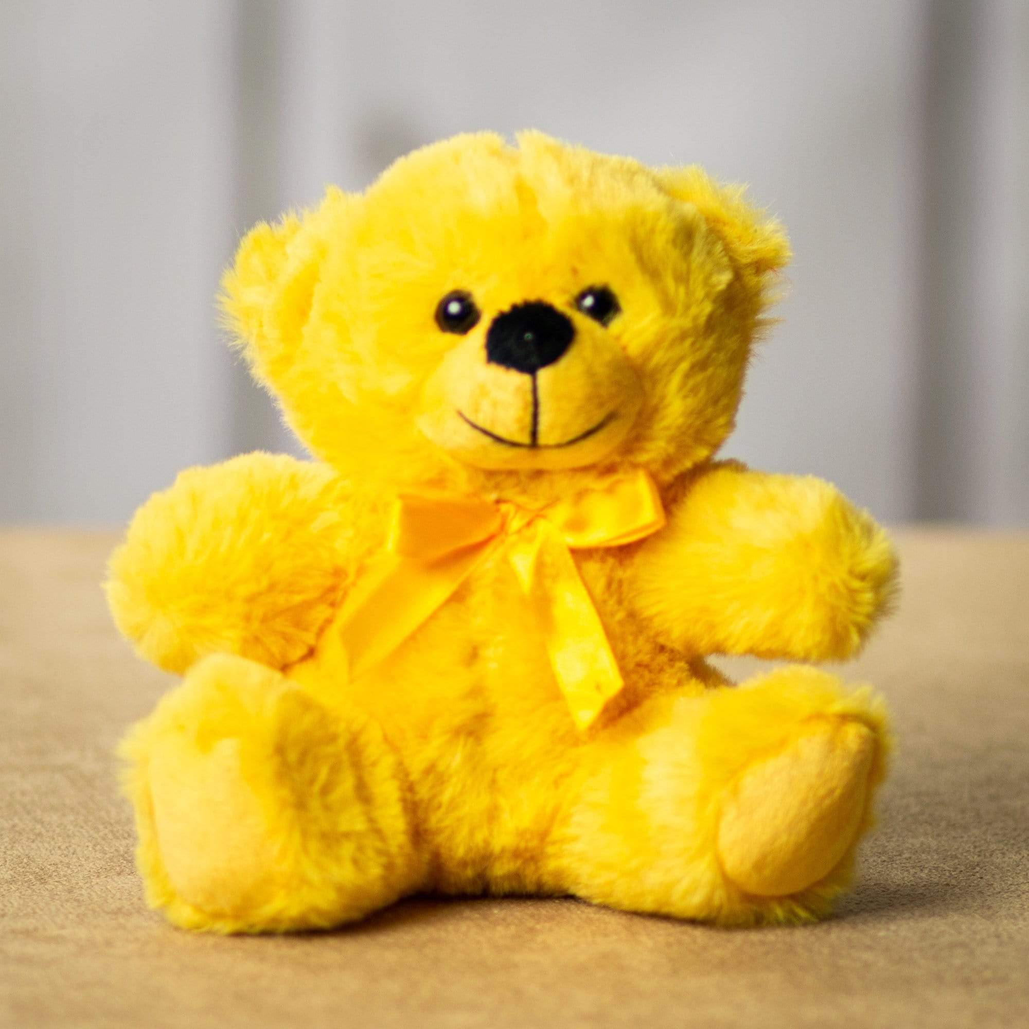 Yellow teddy bear with a ribbon bow