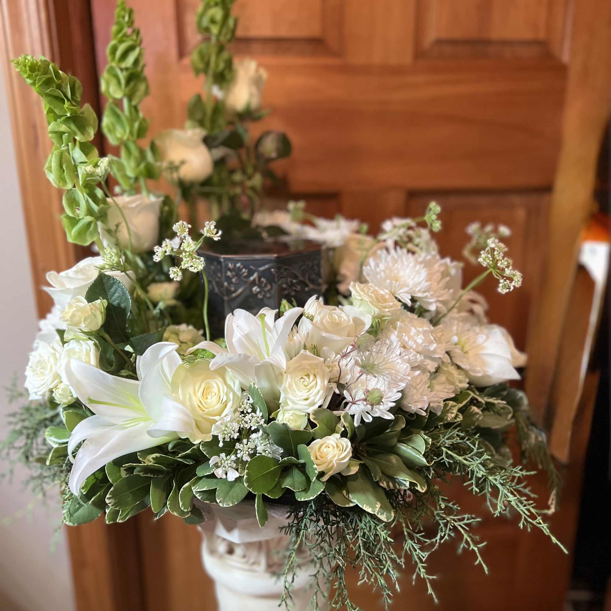 Our all white tribute surrounds the Urn with lilies, Roses, carnations, mums