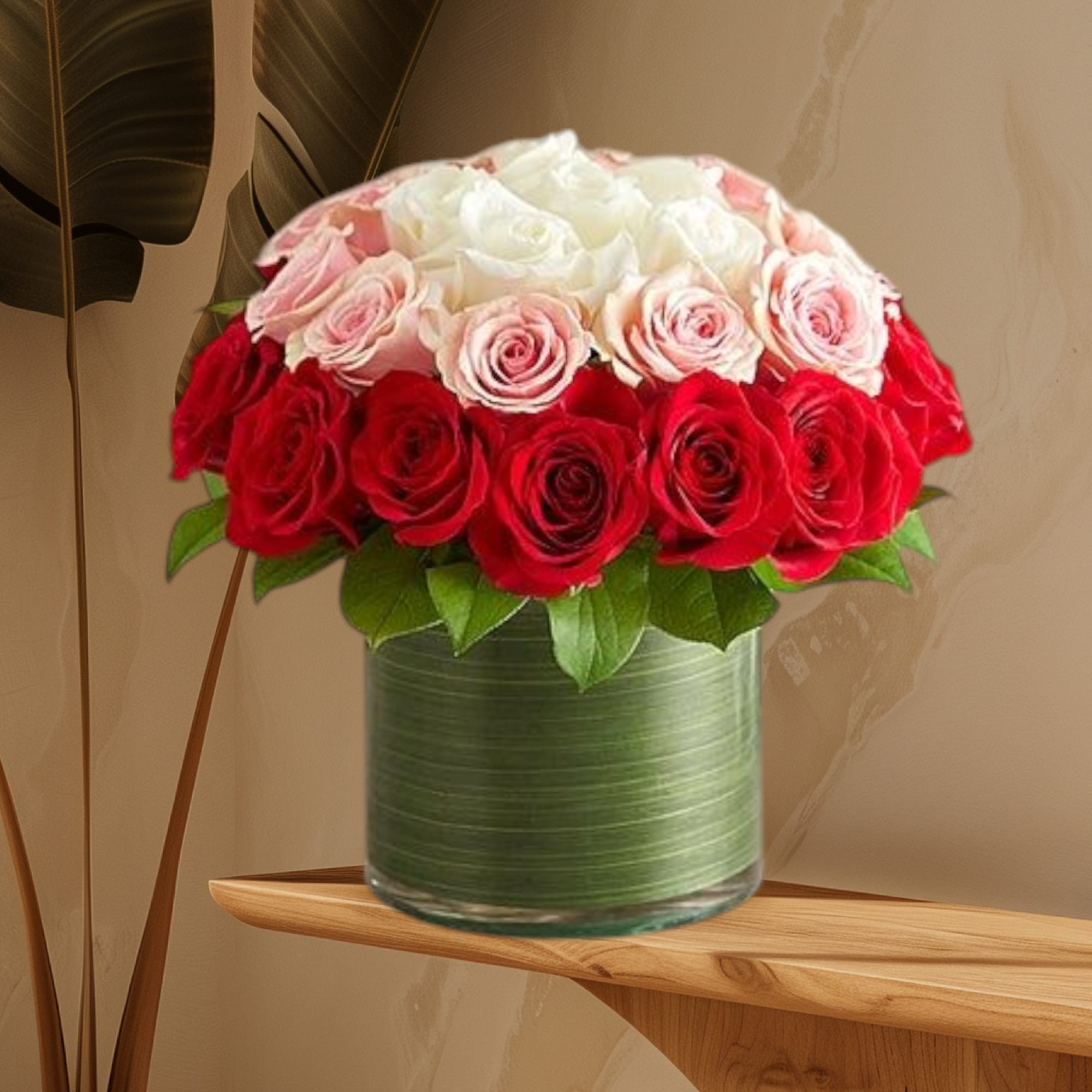 Red, pink, and white roses arranged in a glass vase