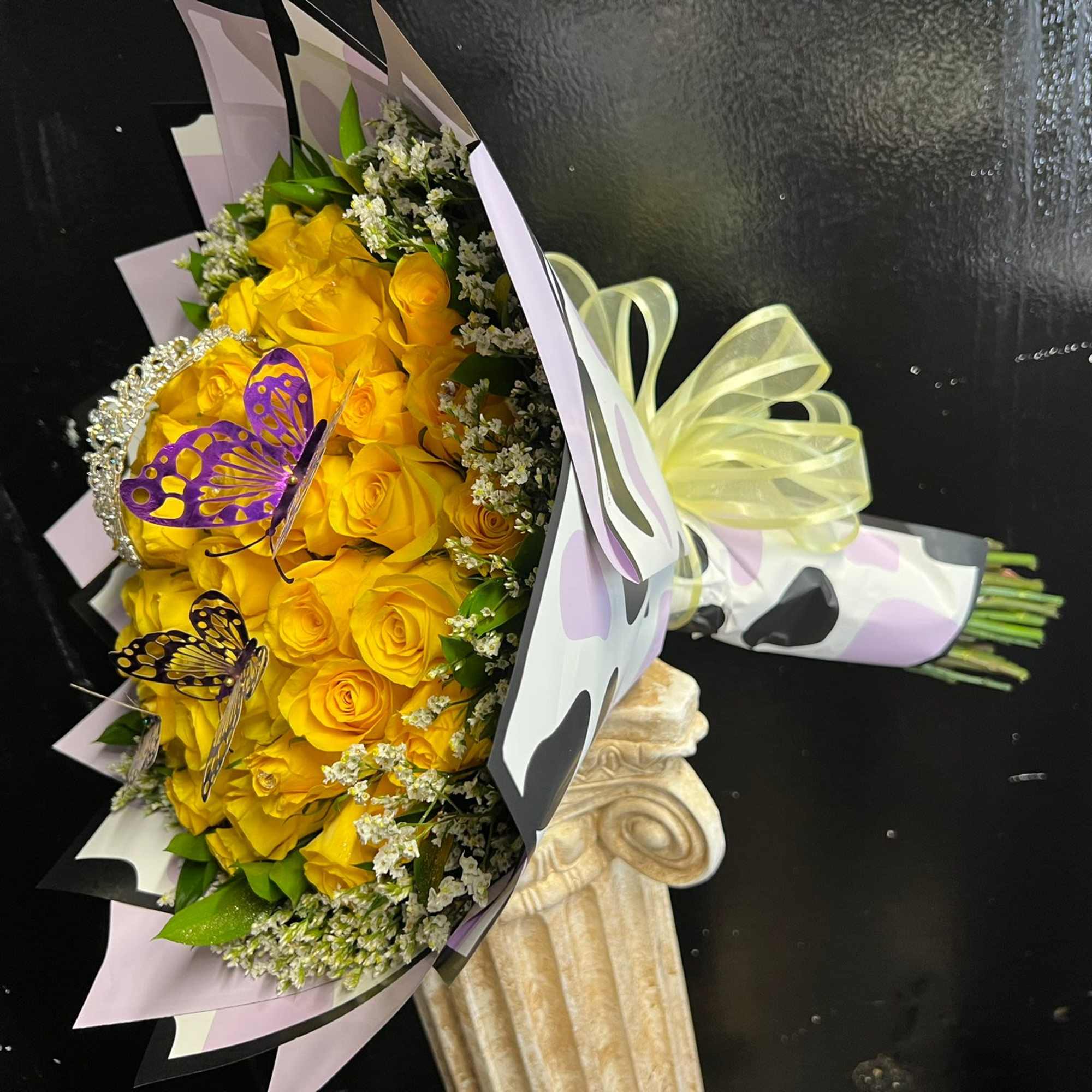 Bouquet of yellow roses with butterfly decorations and pastel wrapping