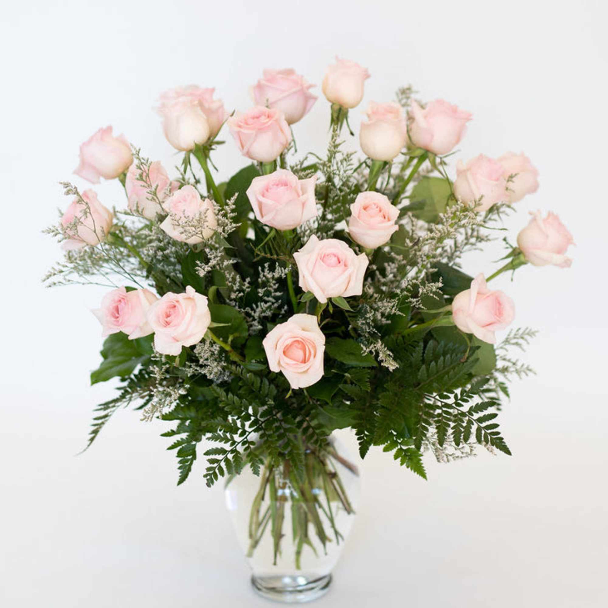 Bouquet of pale pink roses in a clear glass vase