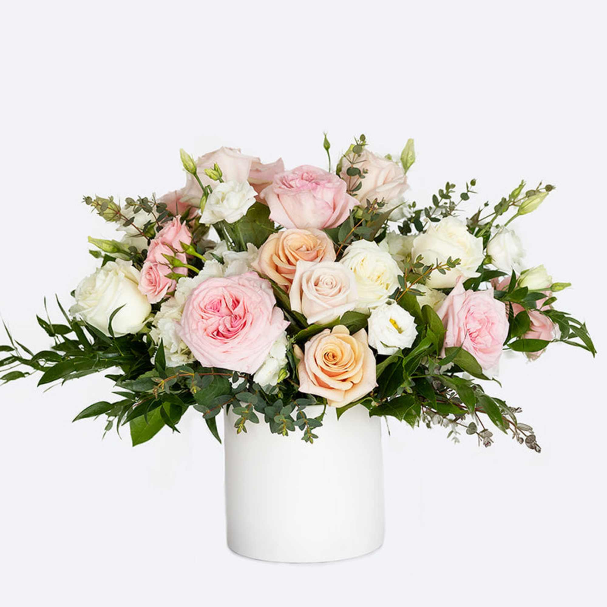 Pink and white roses arranged in a white cylindrical vase