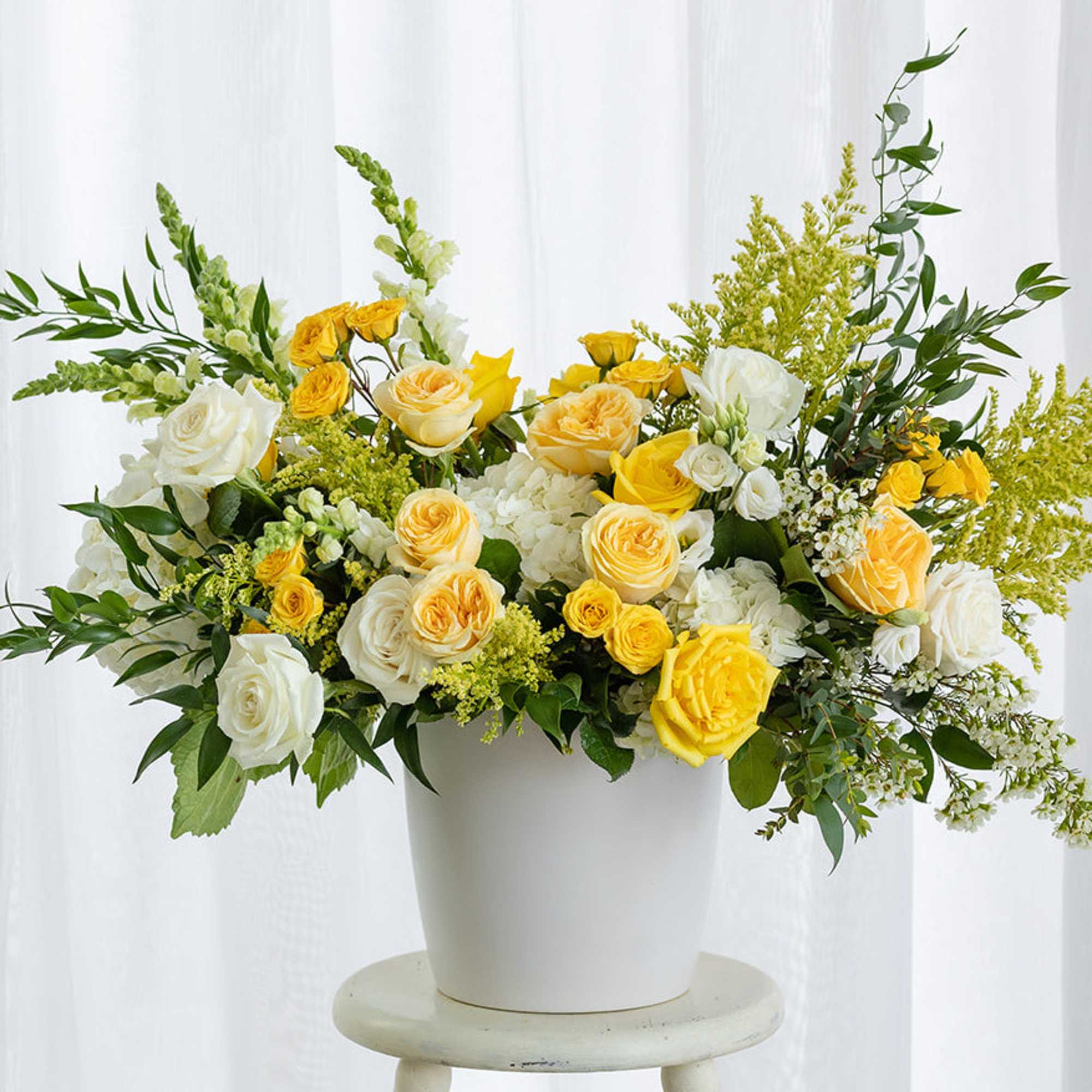 Yellow and white roses in a white vase