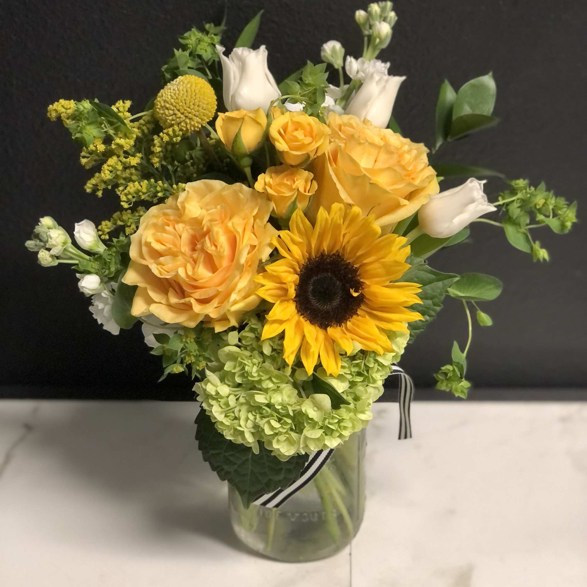 Yellow roses and a sunflower in a glass vase, photo 2 of 2