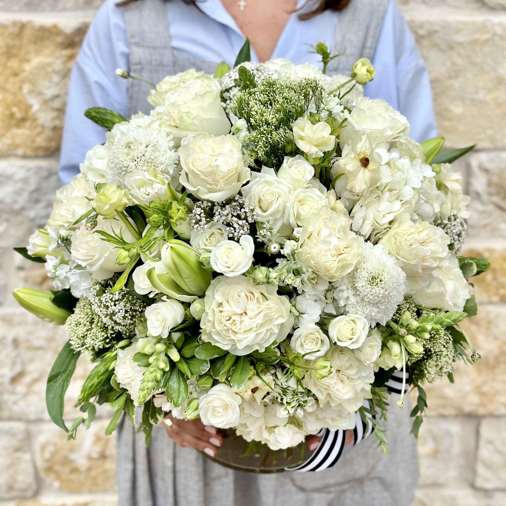 Large white bouquet with roses and lilies in a glass vase