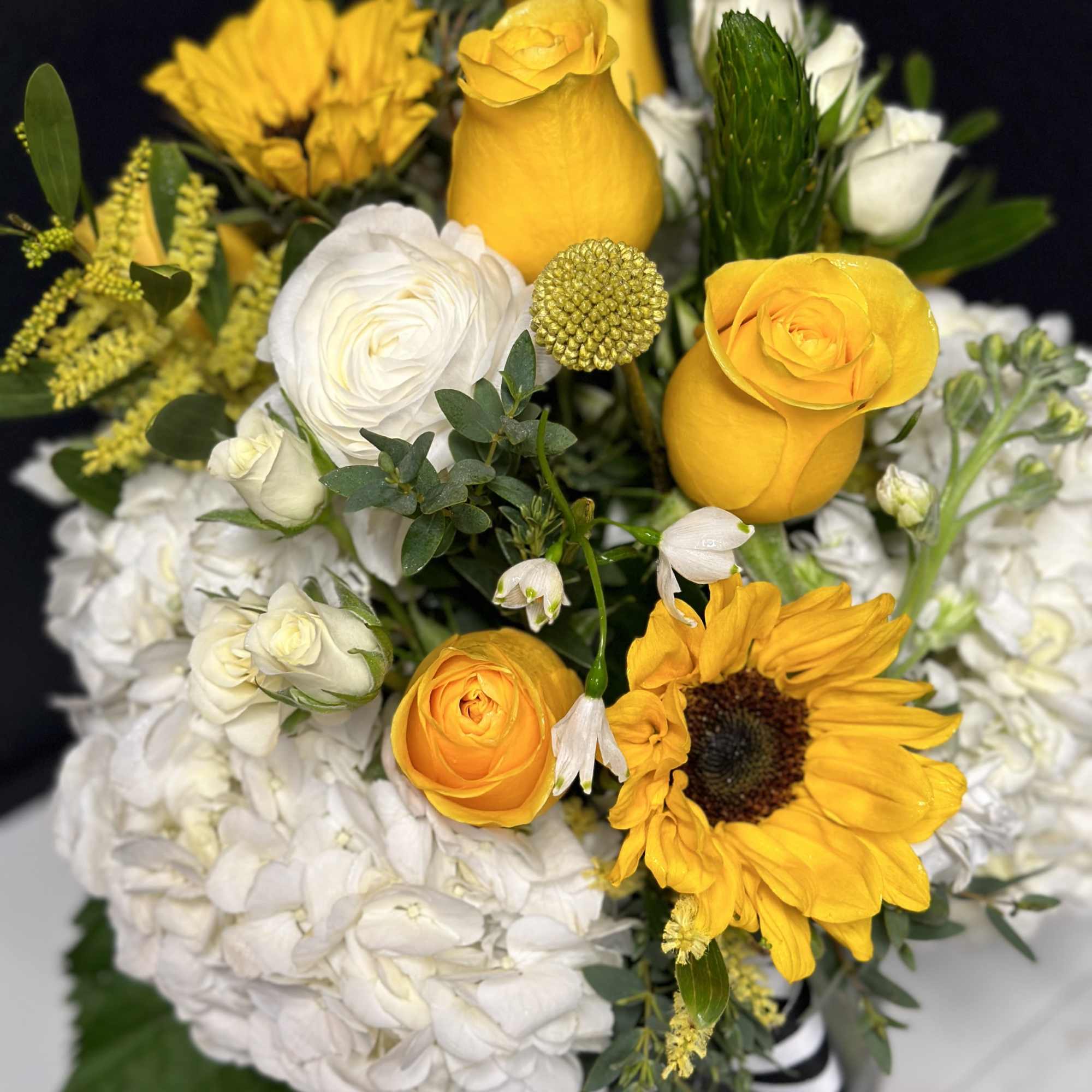 Bouquet of yellow roses, white hydrangeas, and a sunflower