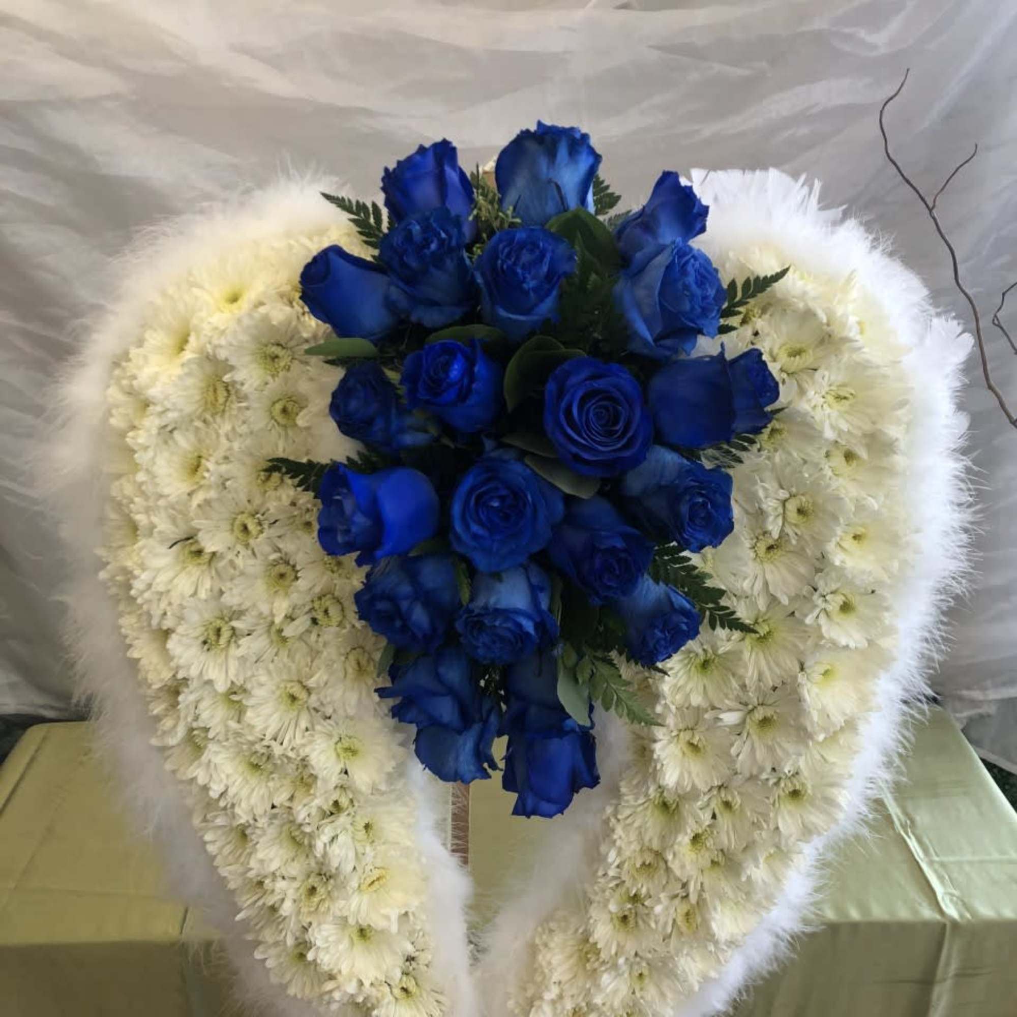 Blue roses in a white floral heart wreath