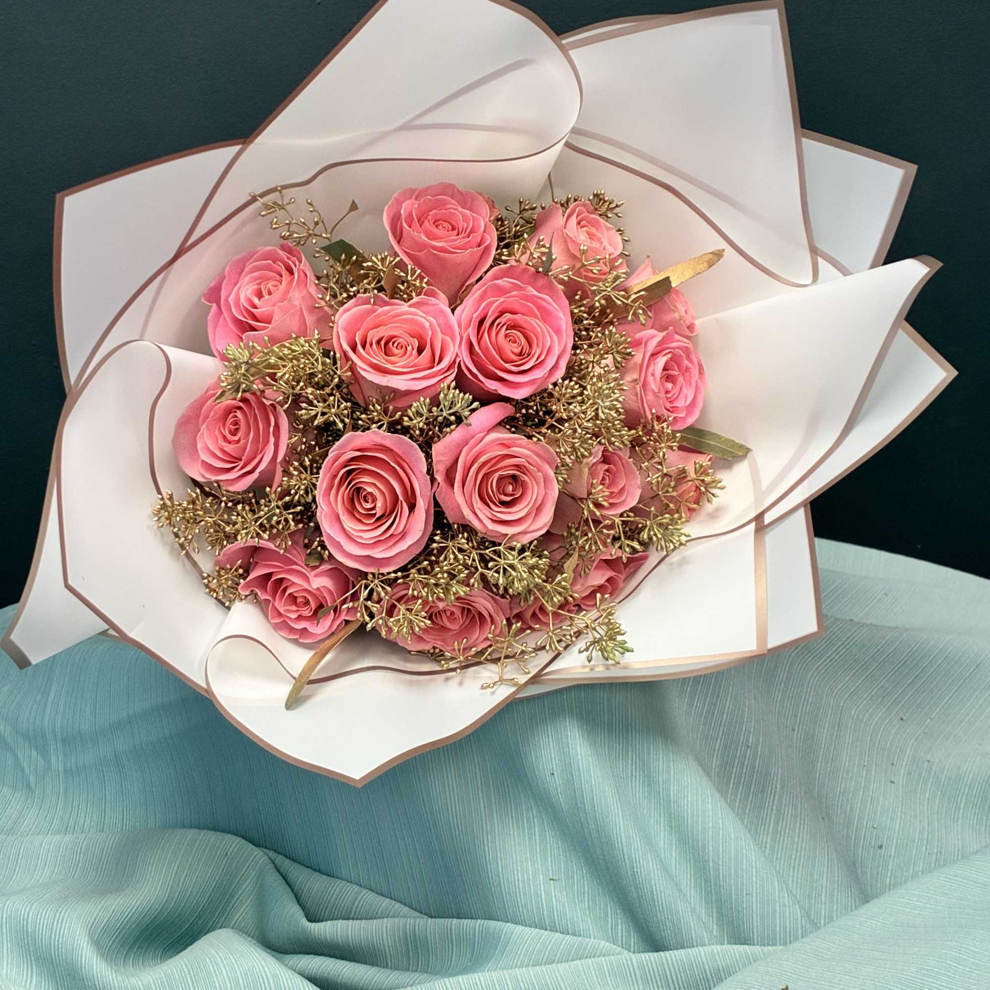 Bouquet of pink roses wrapped in white paper