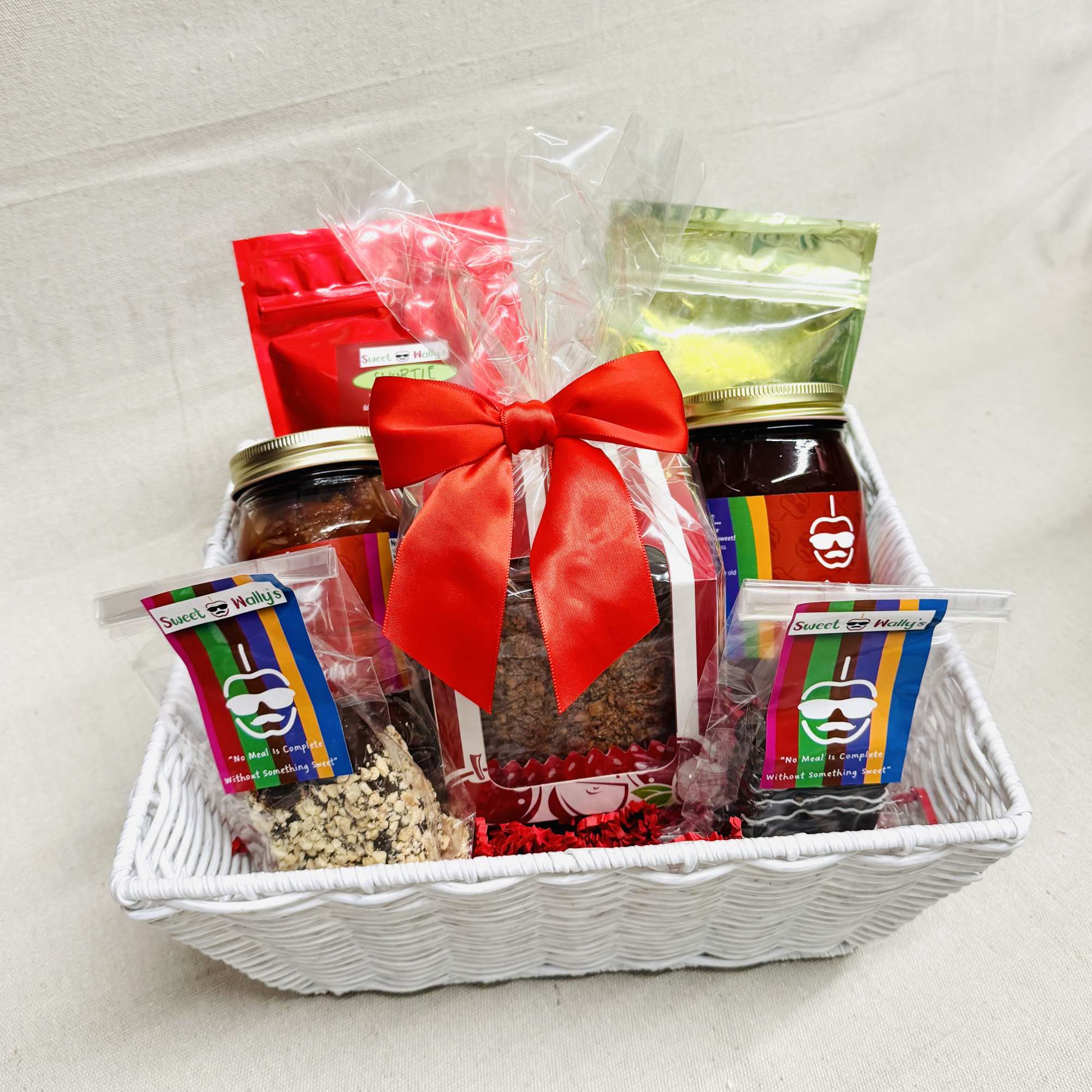 Gift basket with jars and snack packs tied with a red bow