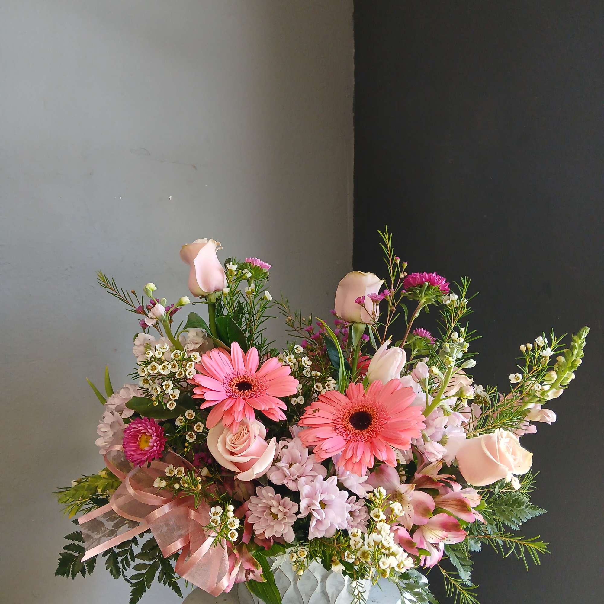 Pink mixed bouquet in a low vase with gerbera daisies and roses